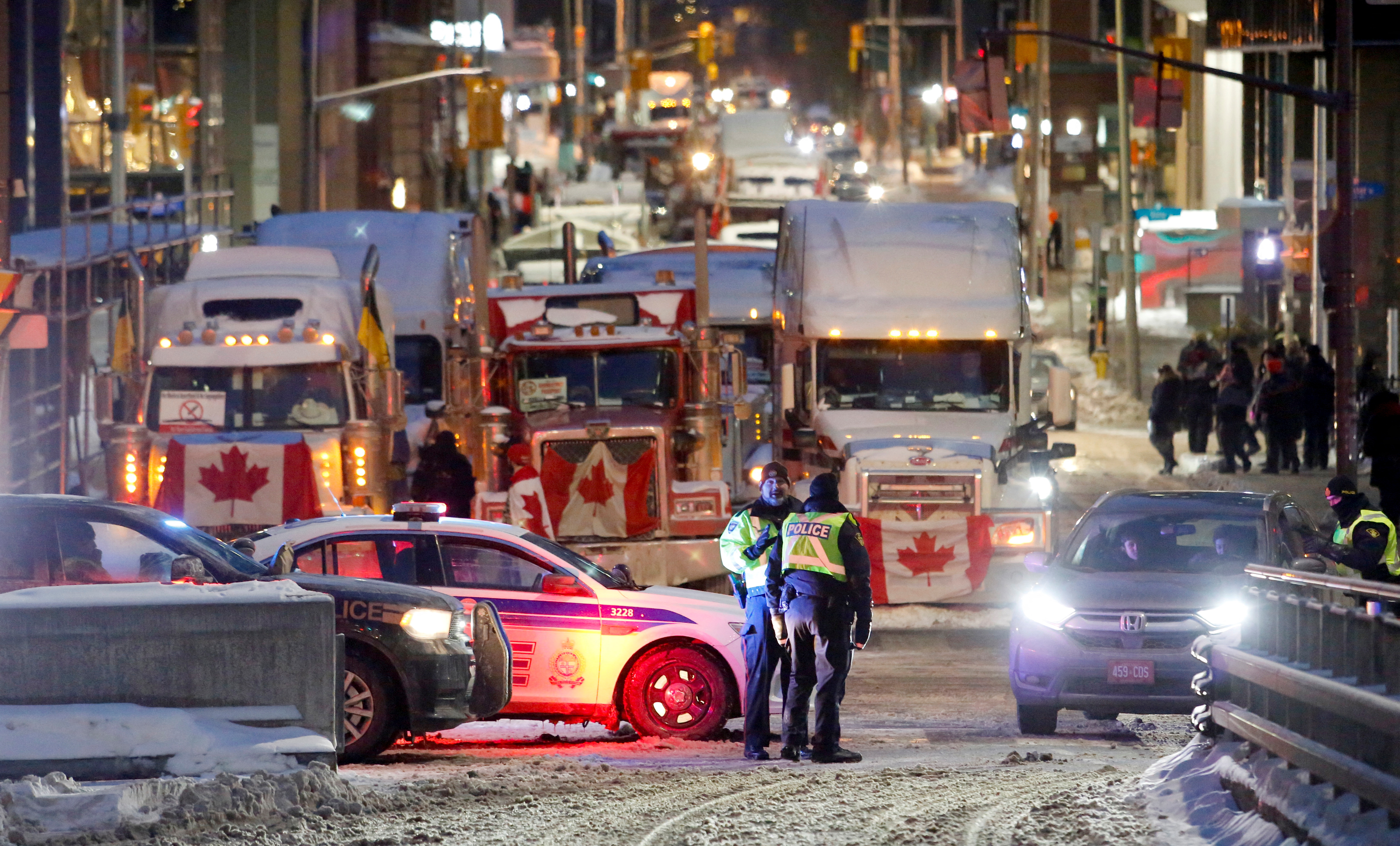 Kanada, Otava, kamiondžije, protest
Police officers stand in front of trucks as truckers and supporters continue to protest coronavirus disease (COVID-19) vaccine mandates, in Ottawa, Ontario, Canada, February 4, 2022. REUTERS/Patrick Doyle
