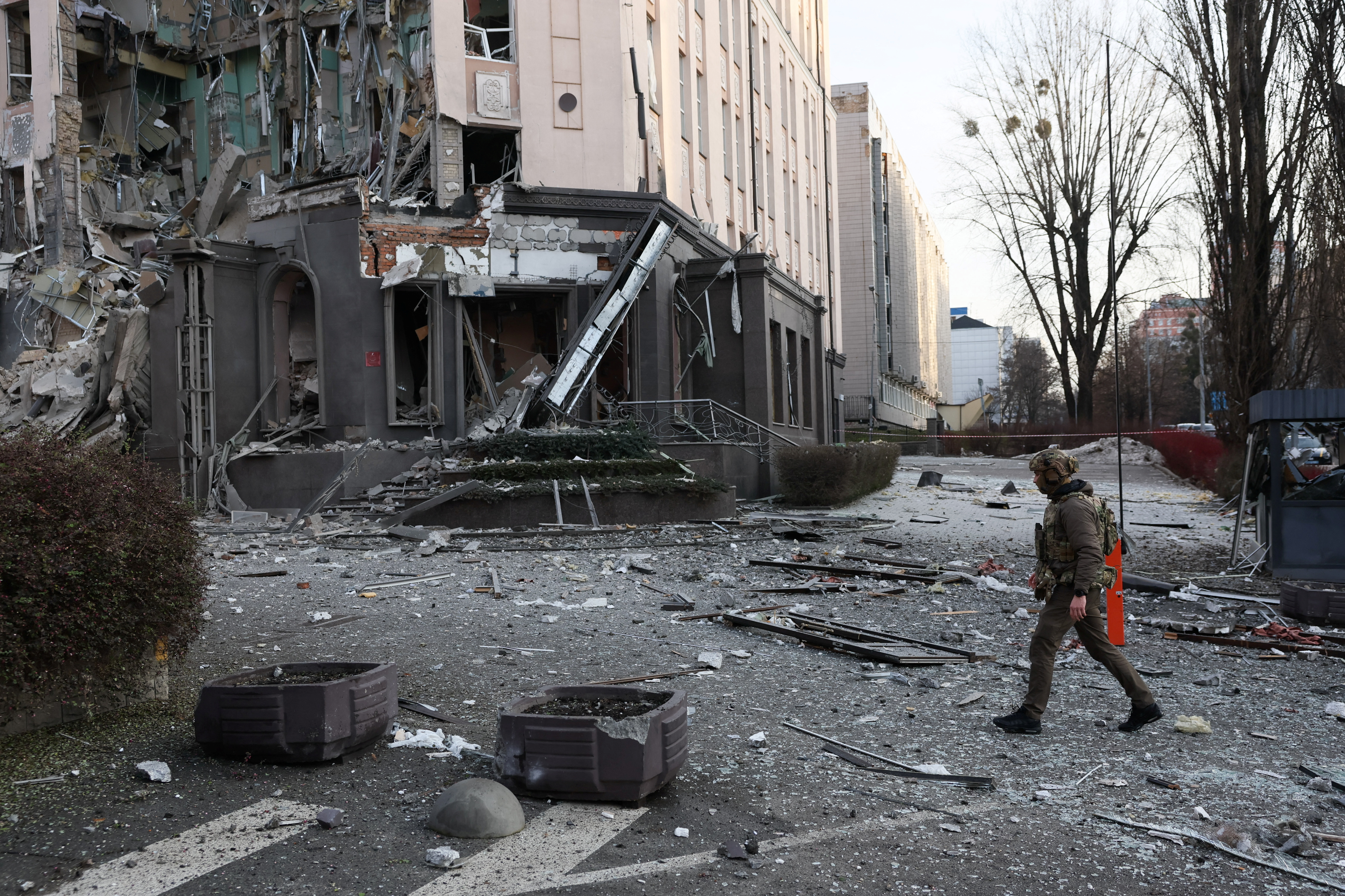 A member of the military walks at the site of a building damaged during a Russian missile strike, amid Russia's attack on Ukraine, in Kyiv, Ukraine December 31, 2022. REUTERS/Gleb Garanich