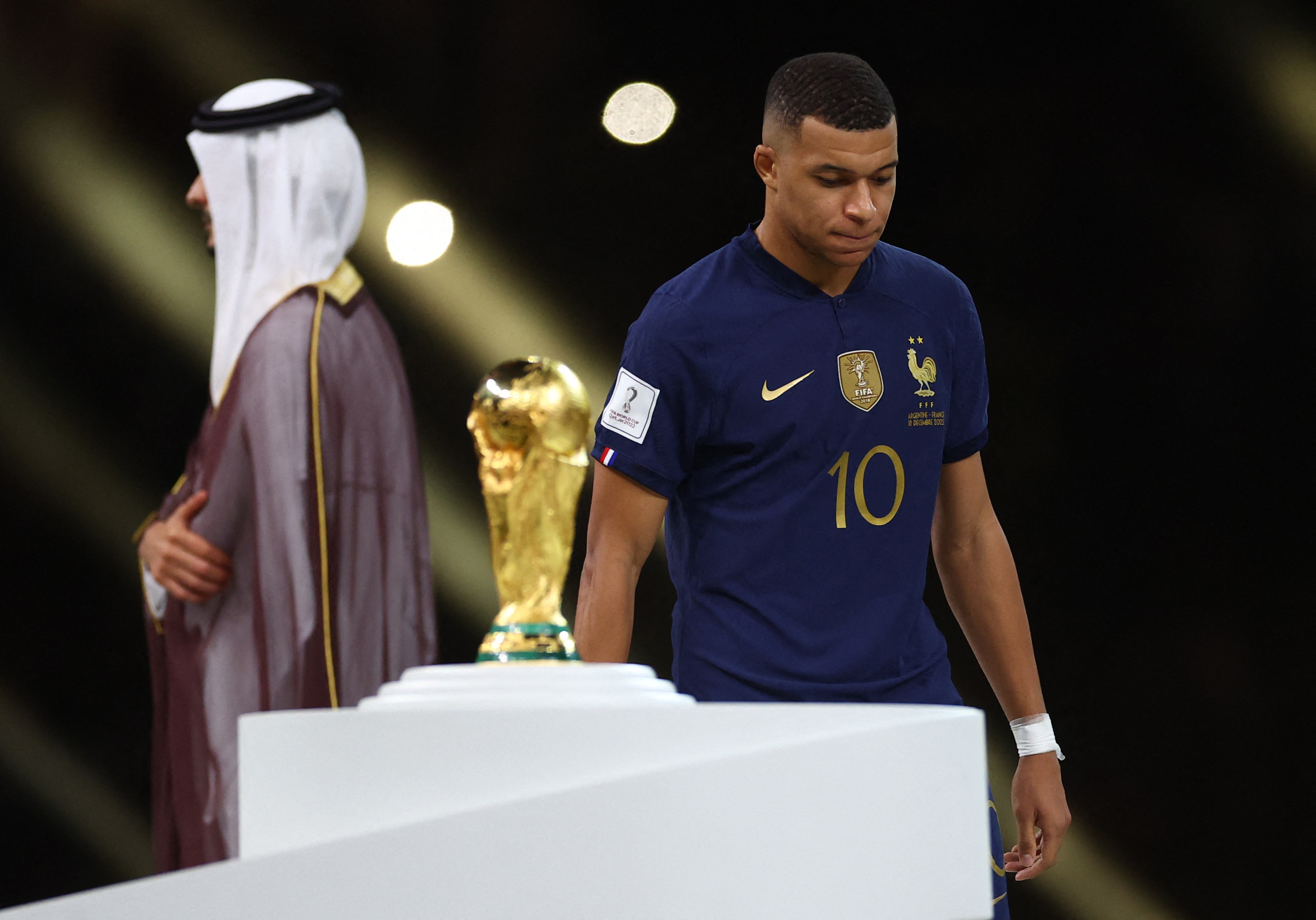 Soccer Football - FIFA World Cup Qatar 2022 - Final - Argentina v France - Lusail Stadium, Lusail, Qatar - December 18, 2022 France's Kylian Mbappe walks past the World Cup trophy after receiving the Golden Boot award REUTERS/Carl Recine