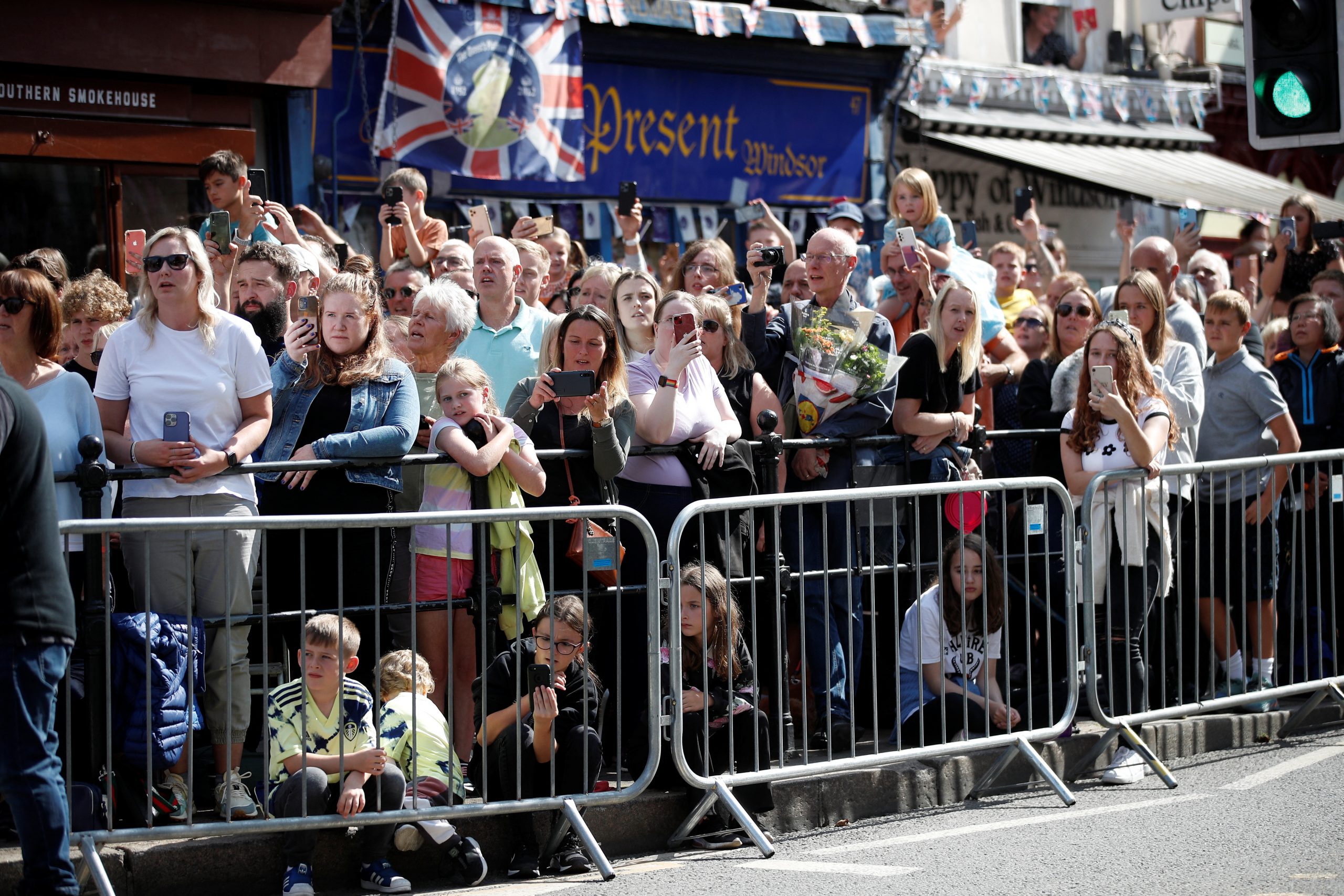 Members of the public watch the Proclamation Ceremony for Britain's King Charles, following the death of Britain's Queen Elizabeth, in Windsor, Britain September 11, 2022. REUTERS/Peter Nicholls
