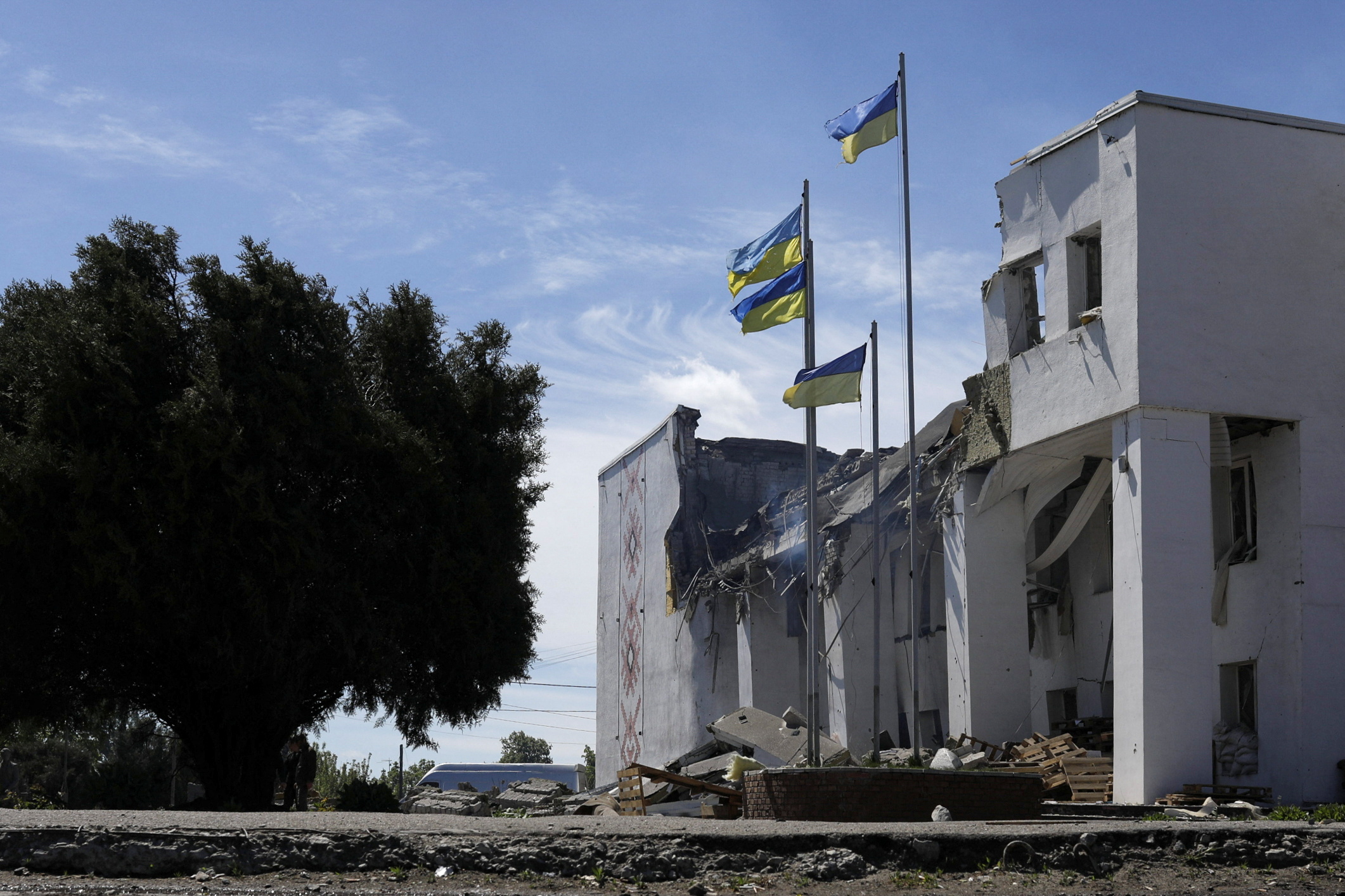 Ukrainian flags are pictured outside the House of Culture in Derhachi, which was used to distribute aid, after a Russian bombing hit it, amid Russia's attack on Ukraine, near Kharkiv, Ukraine, May 13, 2022. REUTERS/Ricardo Moraes