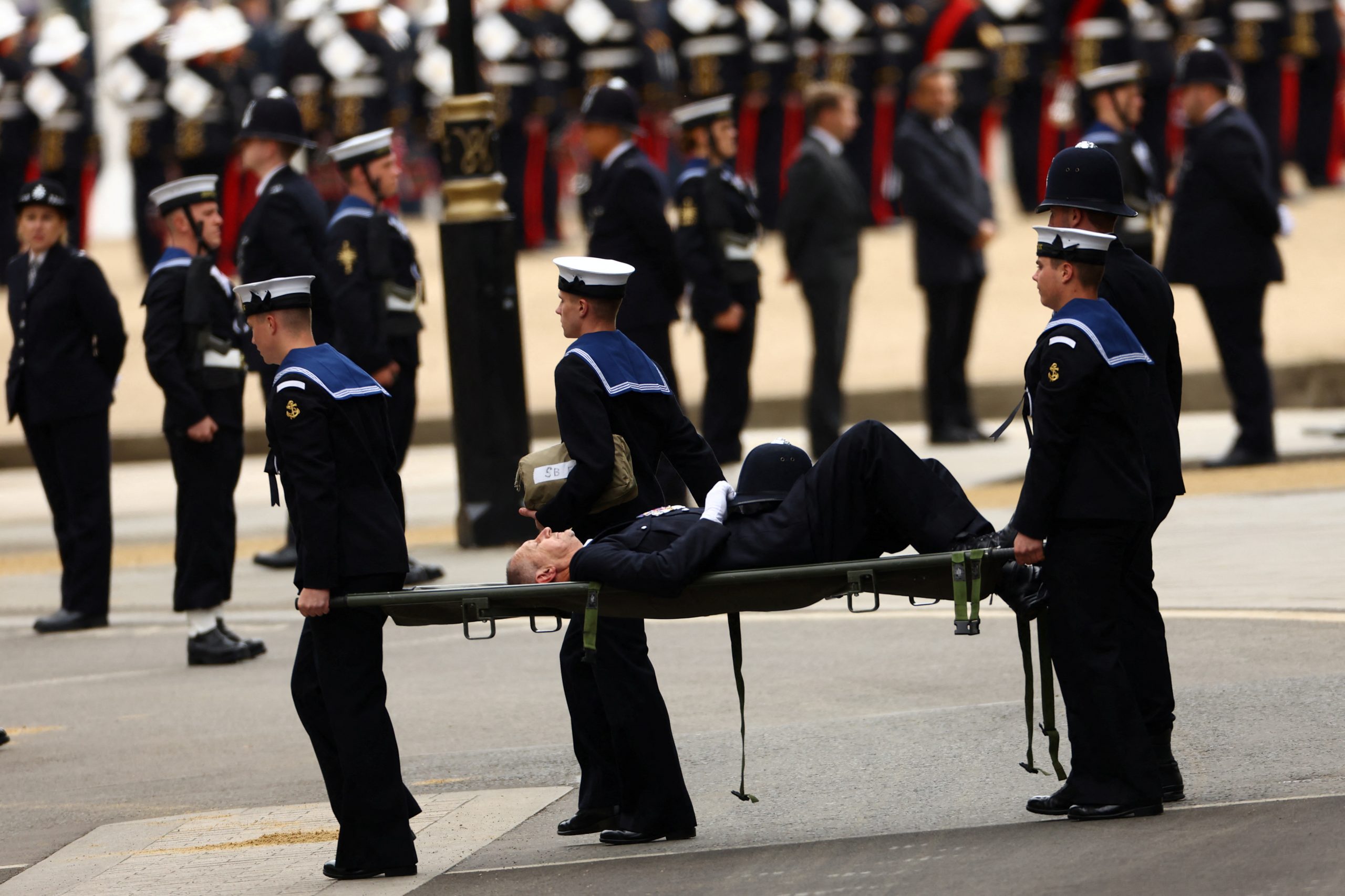 A policeman who collapsed being taken away outside Westminster Abbey on the day of the state funeral and burial of Britain's Queen Elizabeth, in London, Britain, September 19, 2022.  REUTERS/Kai Pfaffenbach sahranakraljica