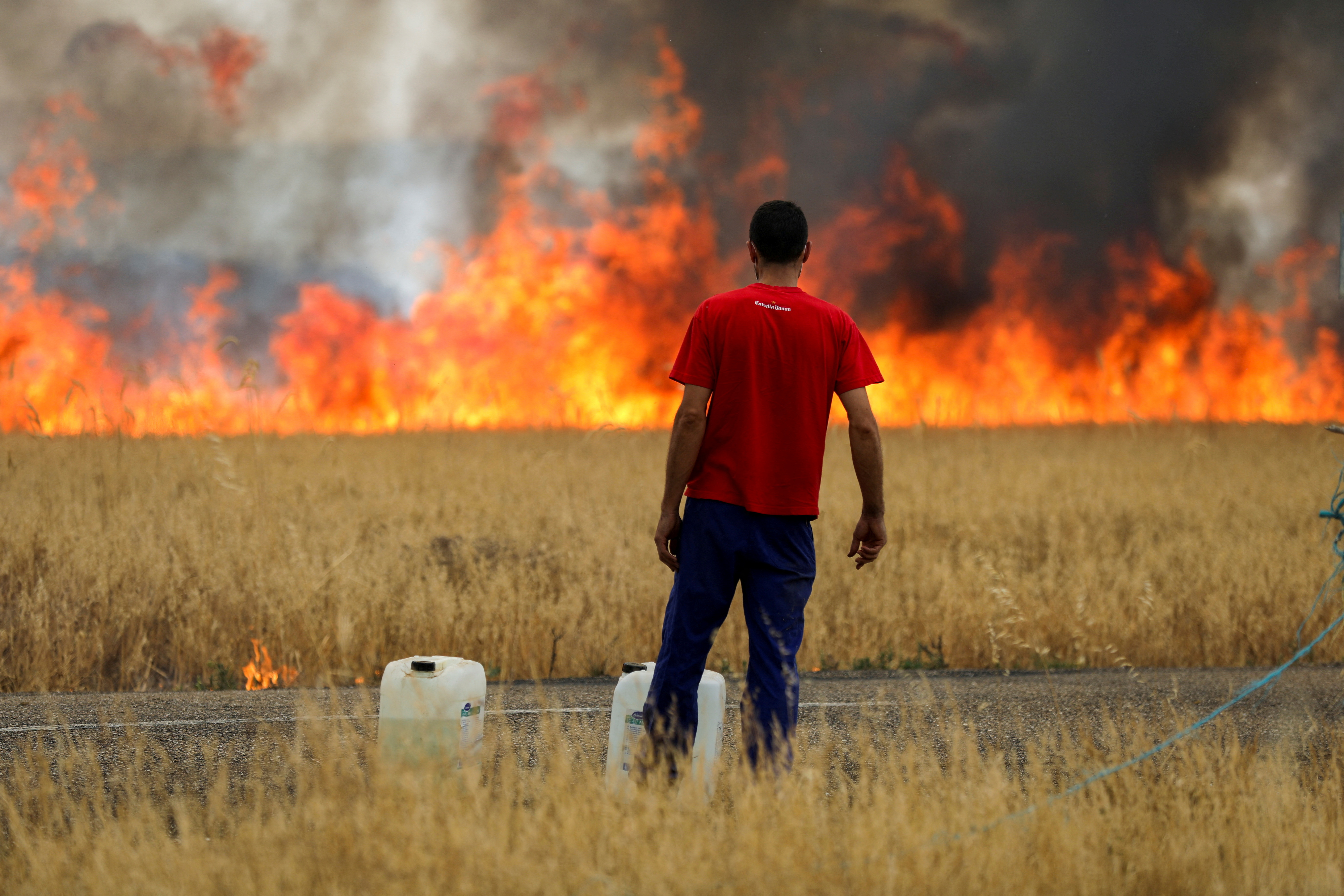 A shepherd watches a fire burning a wheat field between Tabara and Losacio, during the second heatwave of the year, in the province of Zamora, Spain, July 18, 2022. REUTERS/Isabel Infantes     TPX IMAGES OF THE DAY