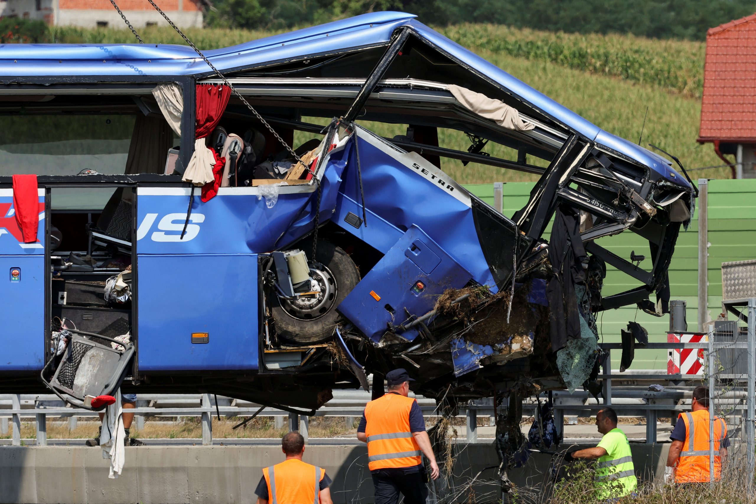 Rescuers work as a crane removes the bus with Polish licence plates that slipped off a road, from the scene near Varazdin, northwestern Croatia, August 6, 2022. REUTERS/Antonio Bronic