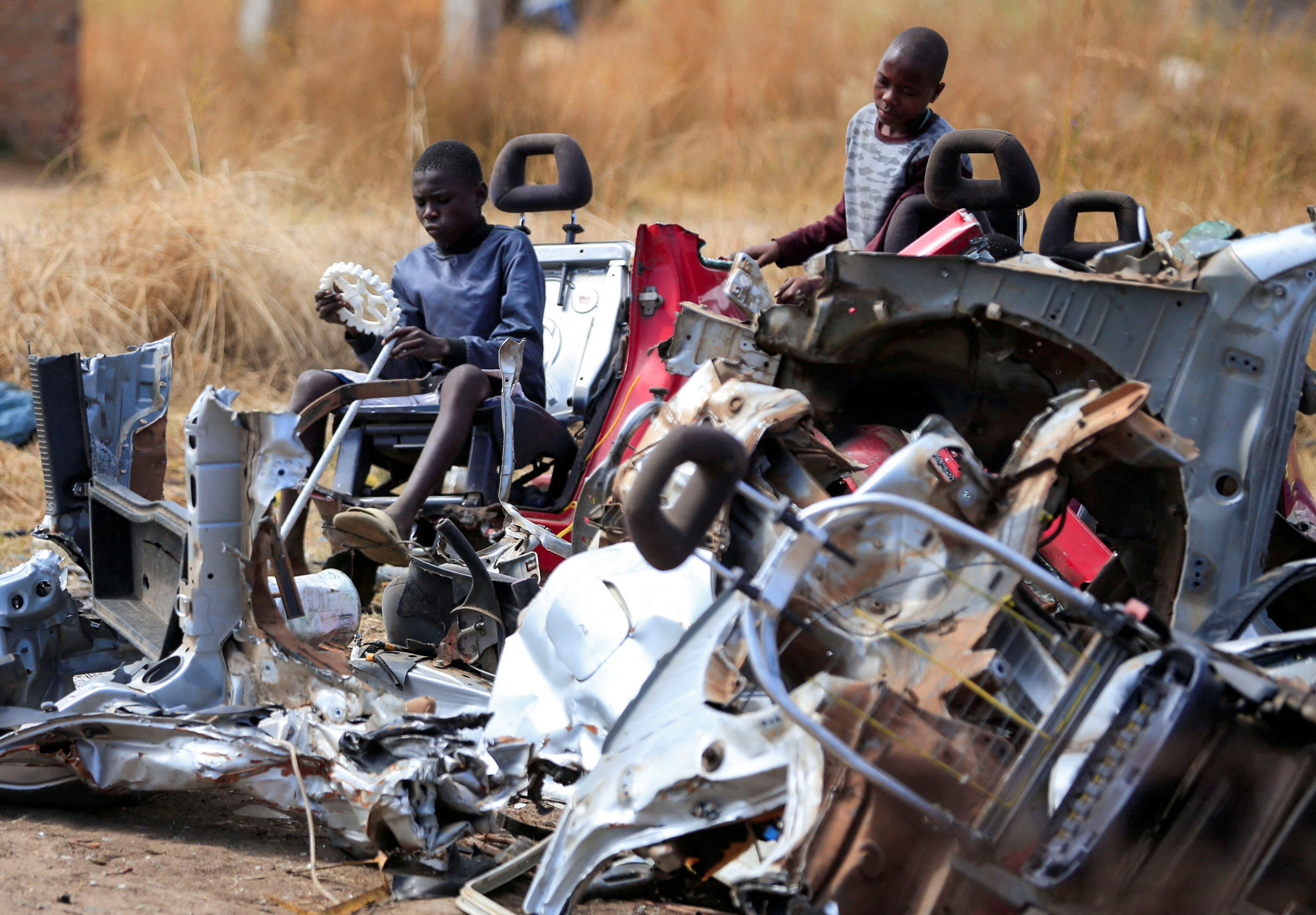 Kids play at a scrap metal collection point in Hopley, a poor settlement about 15 kilometres west of Zimbabwe's capital, Harare, Zimbabwe, July 22, 2022. REUTERS/Philimon Bulawayo     TPX IMAGES OF THE DAY