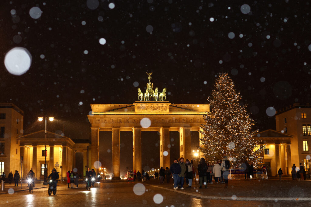 A Christmas tree is illuminated in front of Brandenburg Gate during snowfall in Berlin, Germany, December 1, 2022. REUTERS/Lisi Niesner     TPX IMAGES OF THE DAY