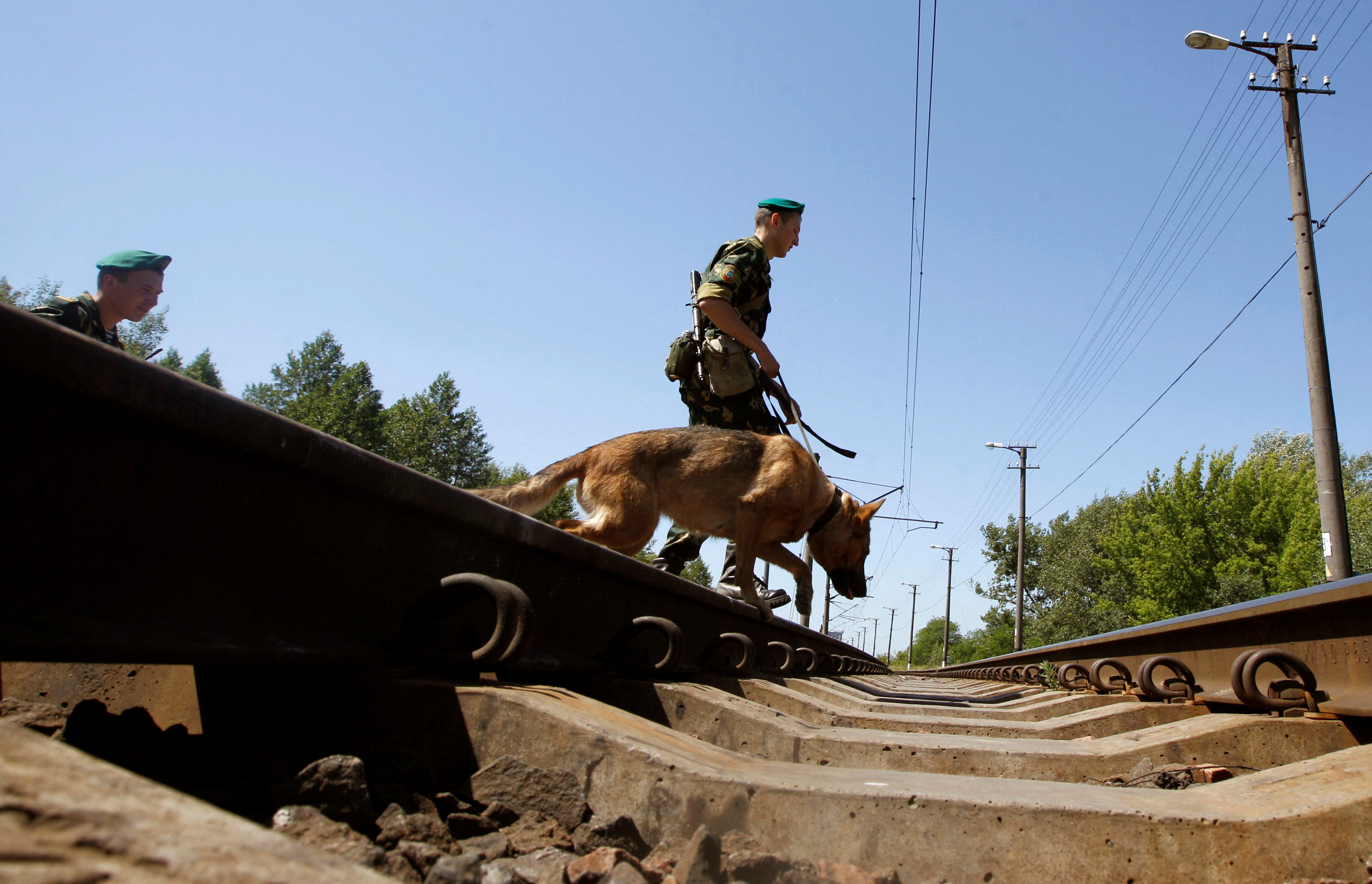FILE PHOTO: Belarussian border guards cross the railways near the Belarus-Poland border on the outskirts of the western city of Brest, some 360 km (223 miles) southeast of Minsk, June 21, 2013.  REUTERS/Vasily Fedosenko/File Photo