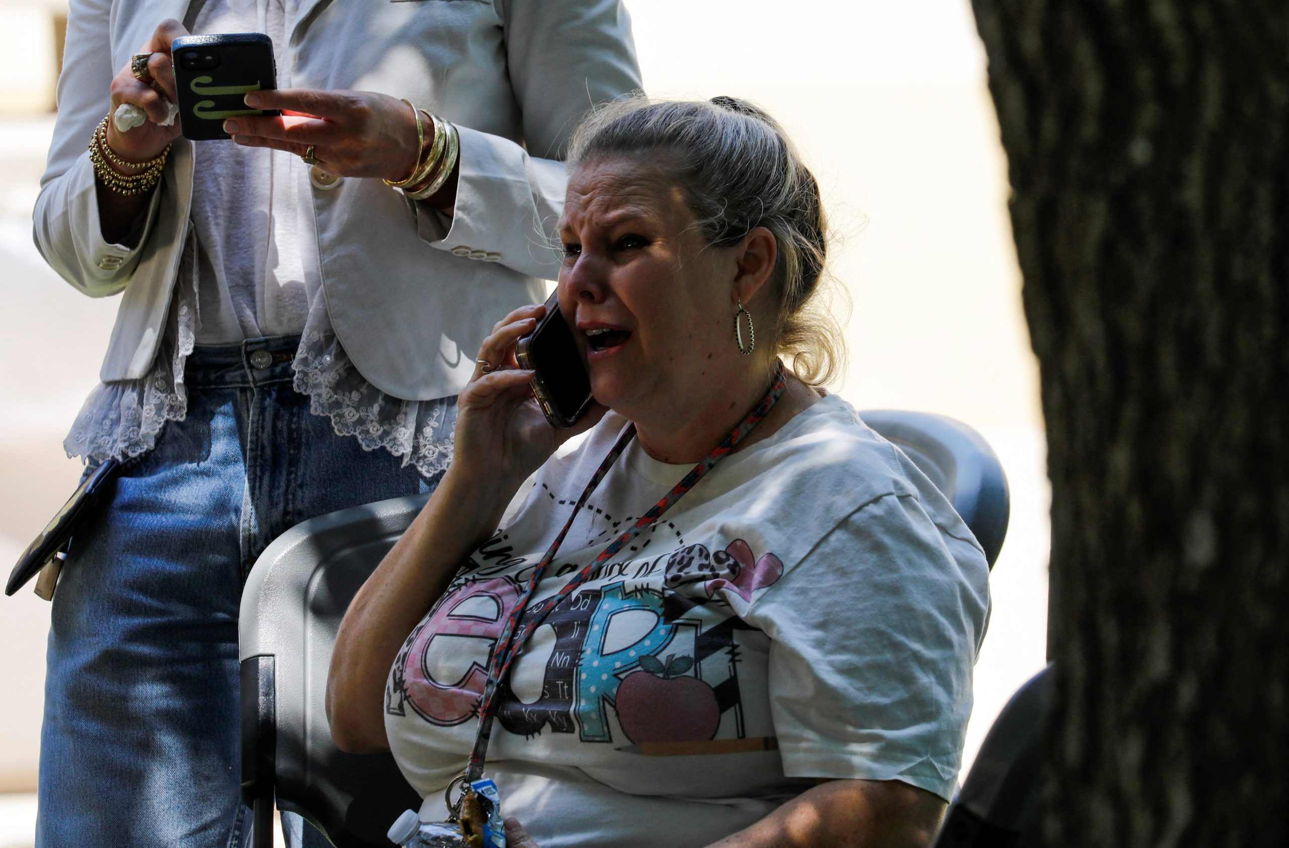 A woman reacts while talking on the phone outside the Ssgt Willie de Leon Civic Center, where students had been transported from Robb Elementary School to be picked up after a suspected shooting, in Uvalde, Texas, U.S. May 24, 2022.  REUTERS/Marco Bello