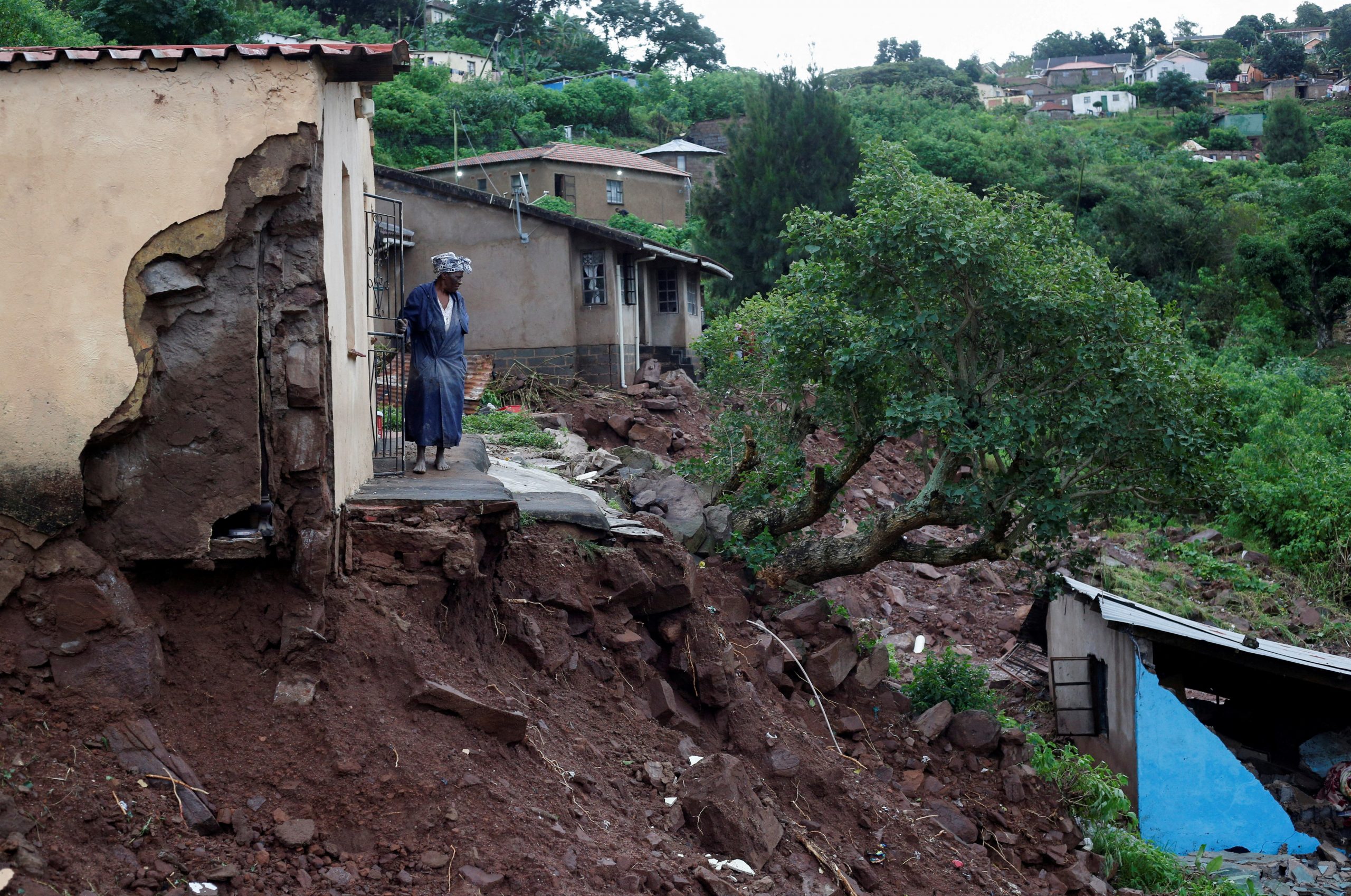 A woman stands at her front door after heavy rains caused flood damage in KwaNdengezi, Durban, South Africa, April 12, 2022. REUTERS/Rogan Ward     TPX IMAGES OF THE DAY
