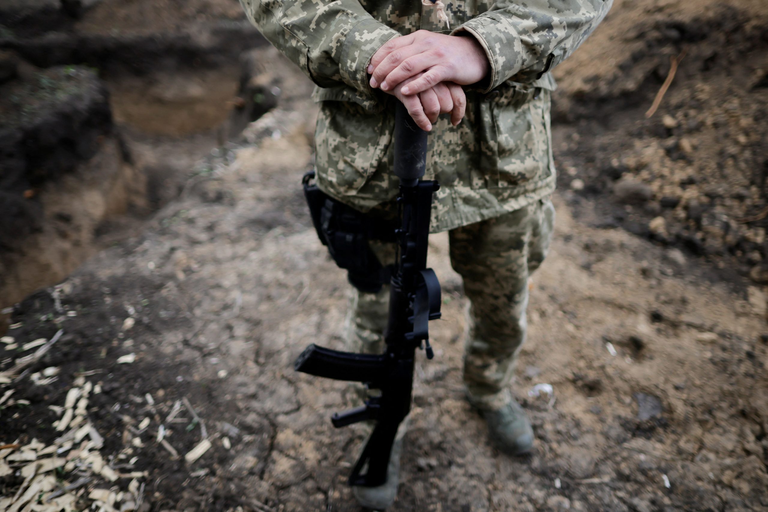 Vitalii, a Ukrainian Army officer, holds his weapon in a trench during tactical exercises at a military camp, amid Russia's invasion of Ukraine, in the Zaporizhzhia region, Ukraine April 30, 2022.  REUTERS/Ueslei Marcelino