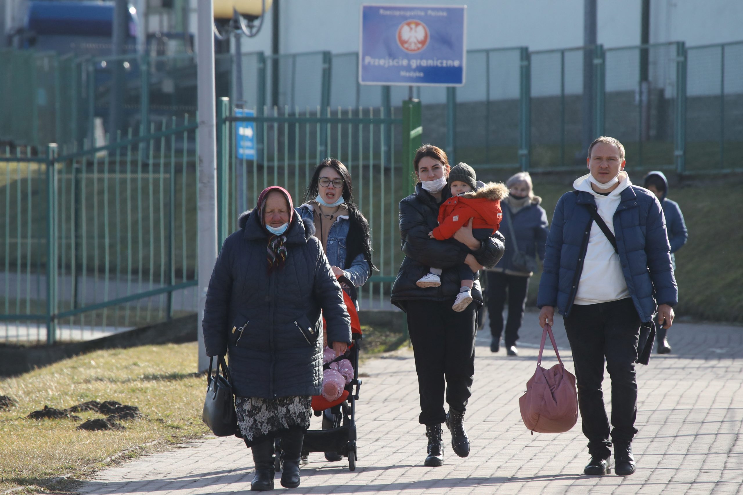 People walk at the border crossing between Poland and Ukraine, after Russian President Vladimir Putin authorized a military operation in eastern Ukraine, in Medyka, Poland, February 24, 2022. REUTERS/Kacper Pempel
