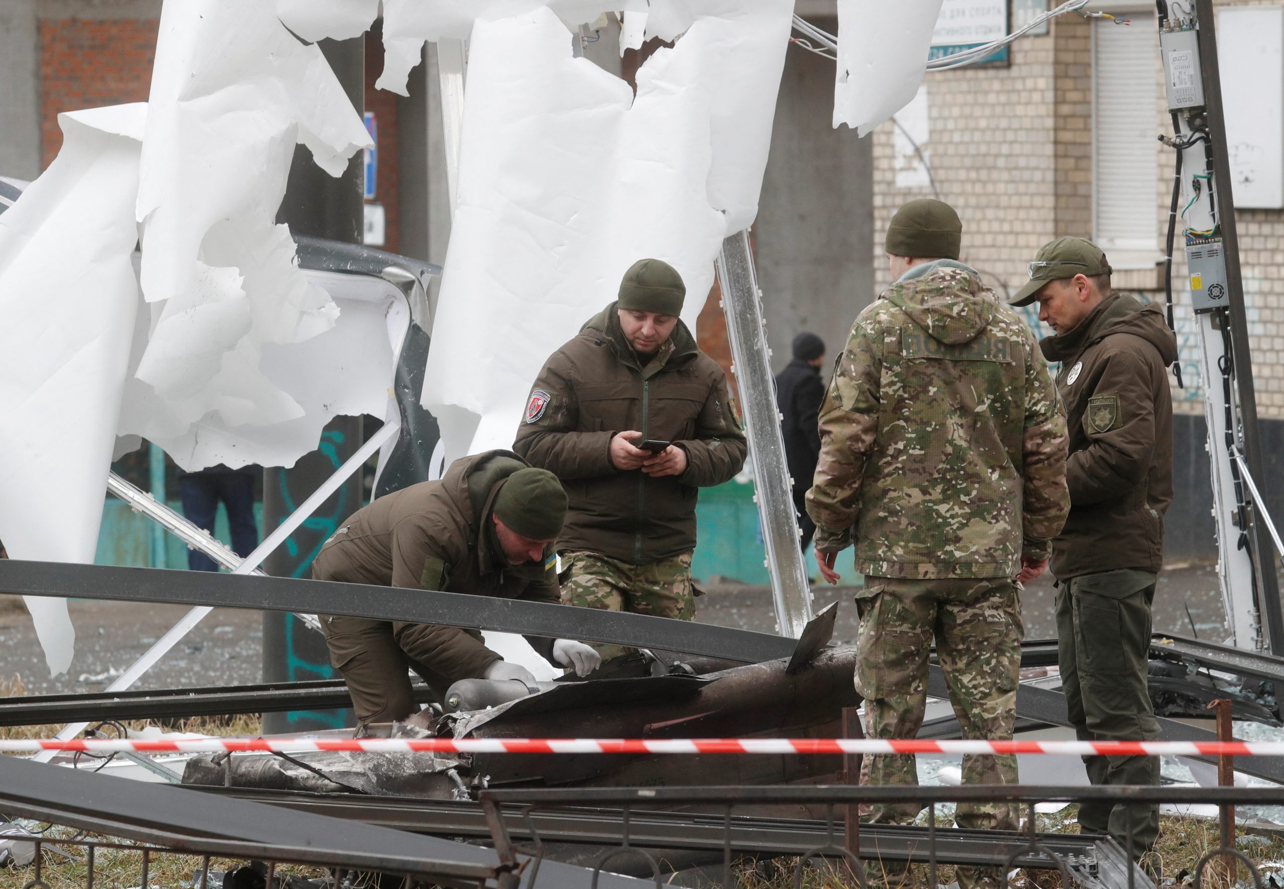 Police officers inspect the remains of a missile that landed in the street, after Russian President Vladimir Putin authorized a military operation in eastern Ukraine, in Kyiv, Ukraine February 24, 2022. REUTERS/Valentyn Ogirenko