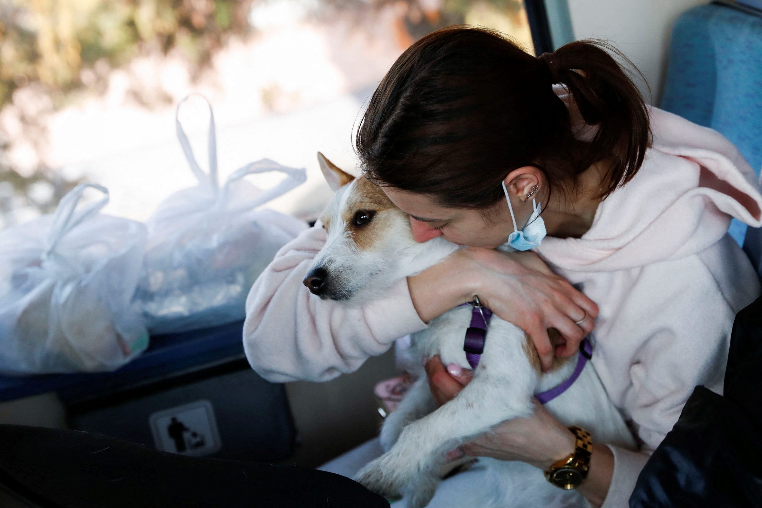 A woman fleeing Russia's invasion of Ukraine holds a dog as she sits on a train to Budapest departing from Zahony, Hungary March 4, 2022. REUTERS/Bernadett Szabo