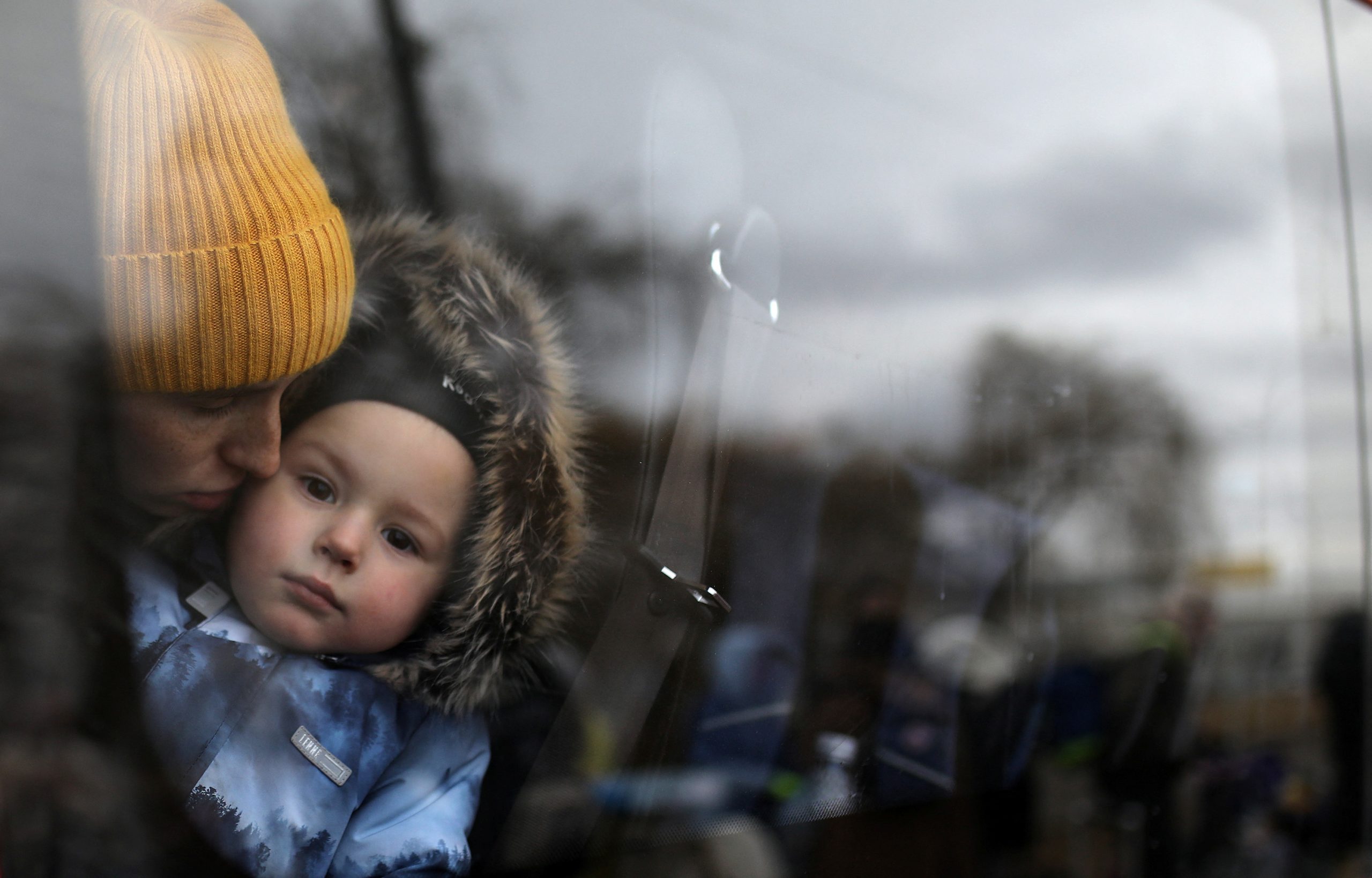A woman and a child wait in a bus after fleeing from Russia's invasion of Ukraine, at the border crossing in Siret, Romania, March 1, 2022. REUTERS/Stoyan Nenov