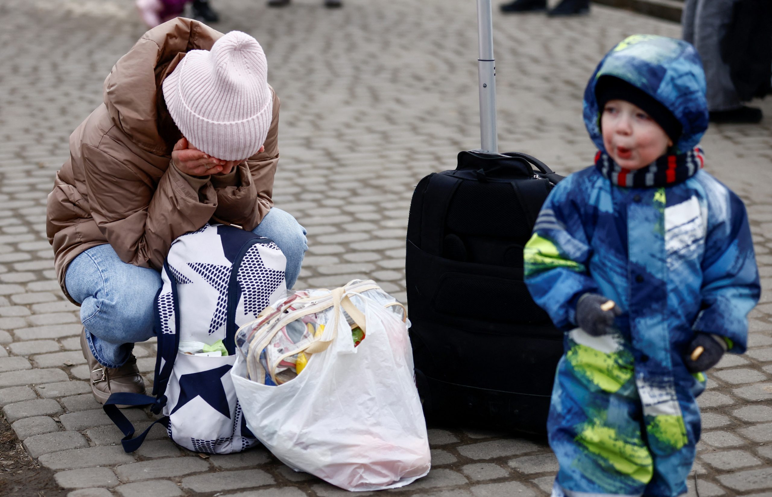 A woman cries after fleeing the Russian invasion of Ukraine with her son, at the border checkpoint in Medyka, Poland, March 4, 2022. REUTERS/Yara Nardi  ukraine izbeglice ljudi
