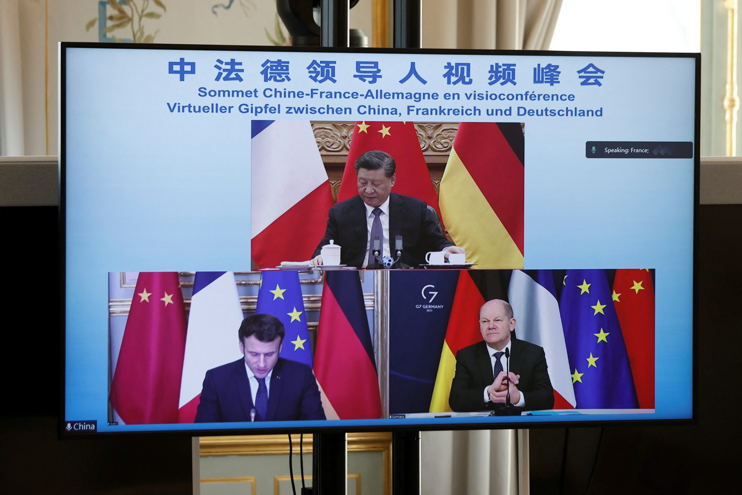 French President Emmanuel Macron, German Chancellor Olaf Scholz and Chinese President Xi Jinping are seen on screen during a video-conference to discuss the Ukraine crisis, at the Elysee Palace in Paris, France, March 8, 2022. REUTERS/Benoit Tessier/Pool