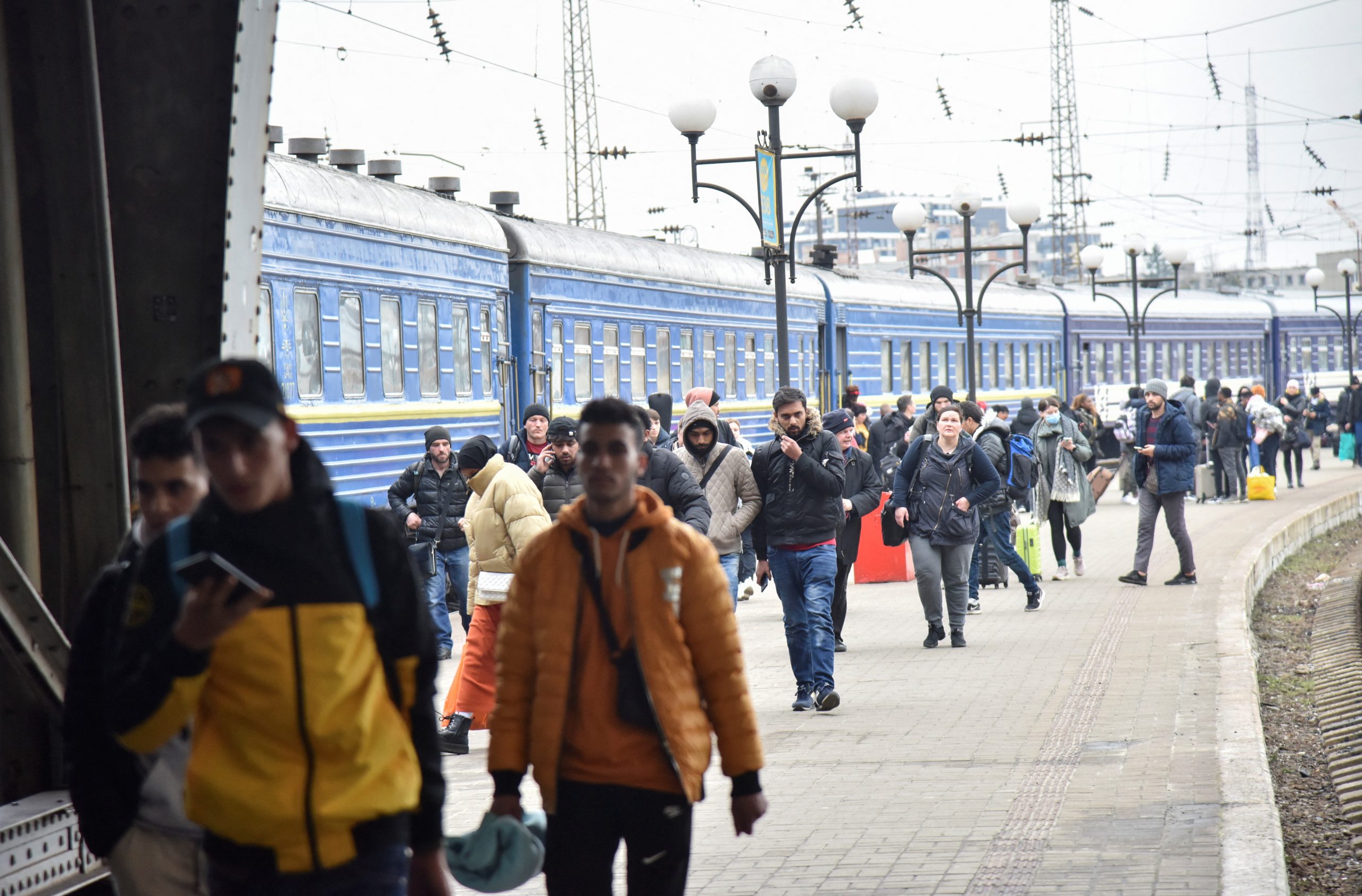 Passengers, including evacuees from the cities of Sumy and Kyiv, walk along the platform of a railway station upon their arrival in Lviv, Ukraine February 25, 2022. REUTERS/Pavlo Palamarchuk