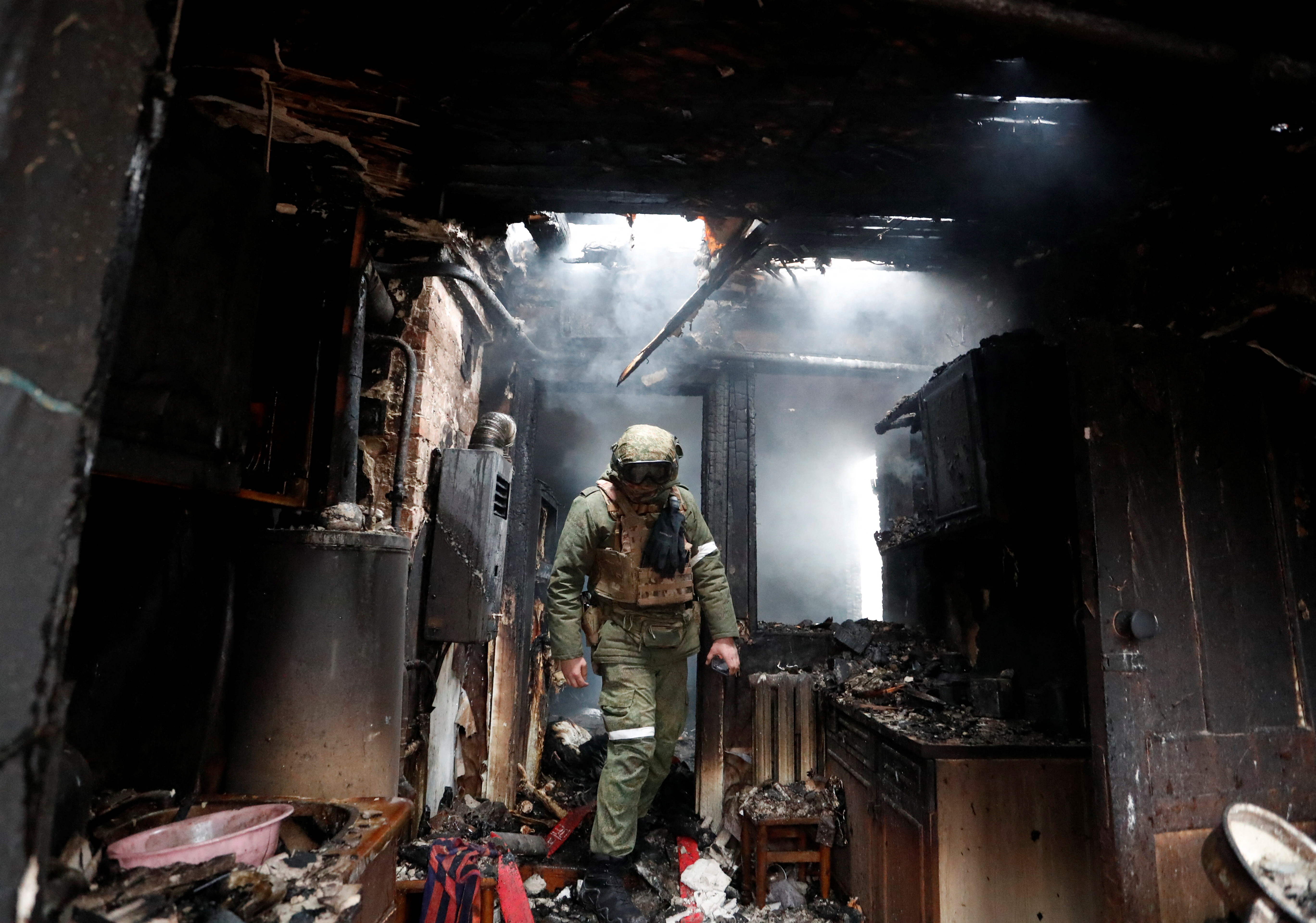 A serviceman of pro-Russian militia walks inside a house that was damaged by recent shelling, in the separatist-controlled city of Donetsk, Ukraine February 28, 2022. REUTERS/Alexander Ermochenko