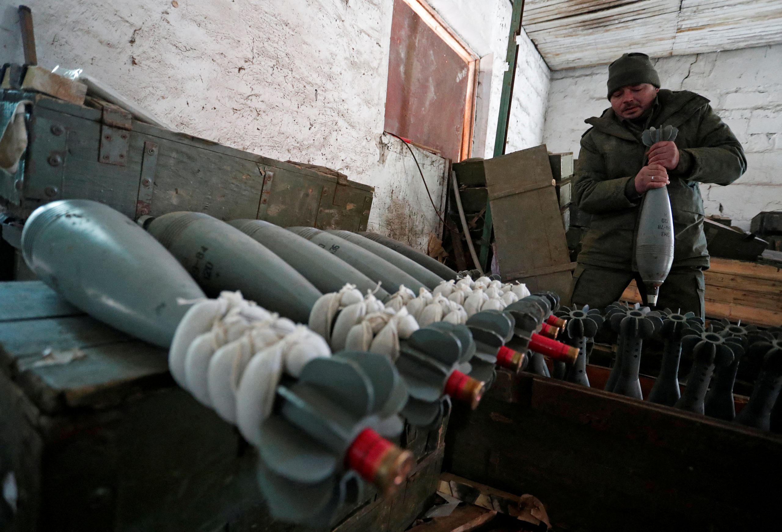 A service member of pro-Russian troops in uniform without insignia handles a mortar round at the weapons depot during Ukraine-Russia conflict near Marinka, in the Donetsk Region, Ukraine March 22, 2022. REUTERS/Alexander Ermochenko TPX IMAGES OF THE DAY
