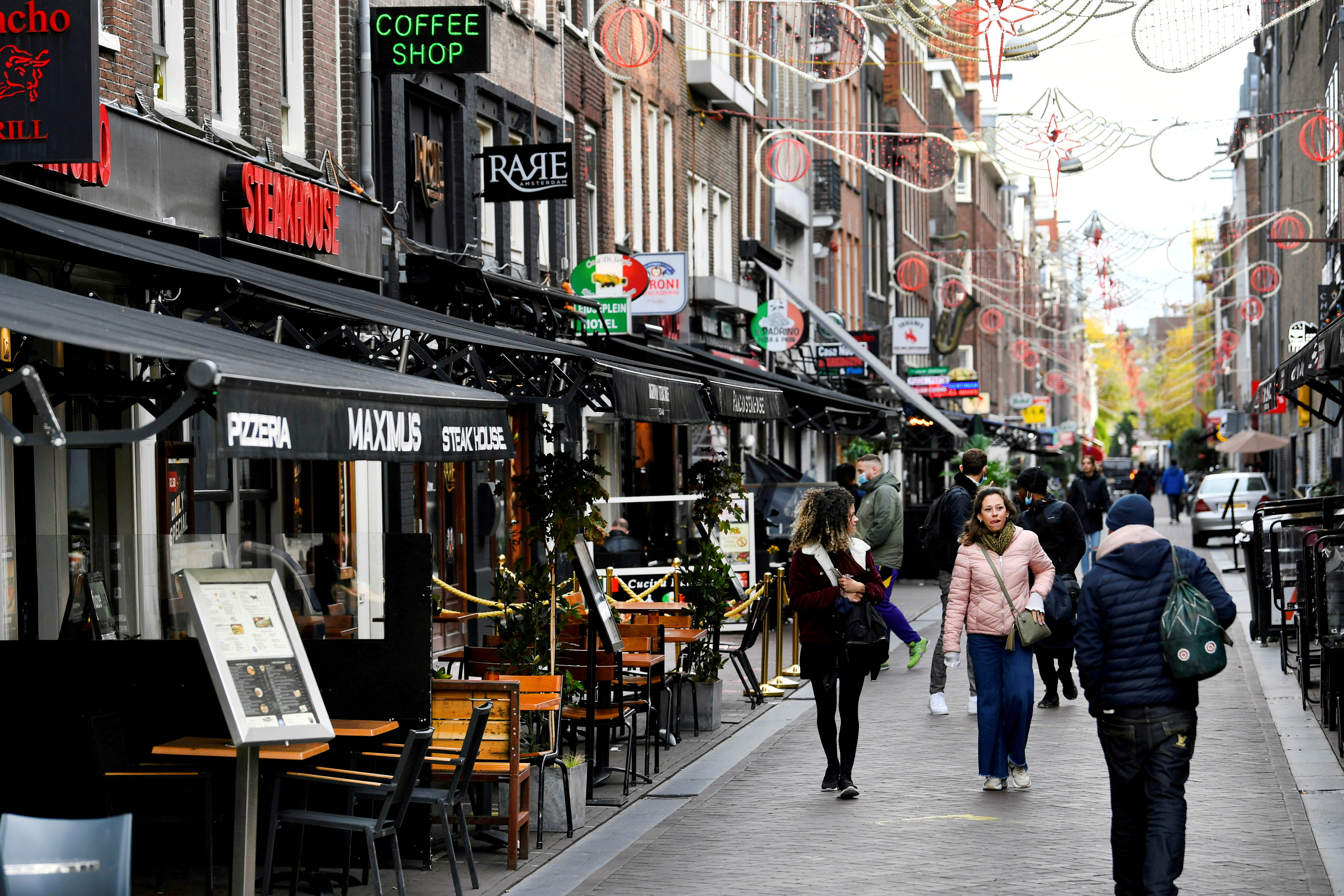 Članice Evropske unije „dižu uzbunu“ unije zbog rasta broja zaraženih FILE PHOTO: People walk past restaurants and bars in Amsterdam