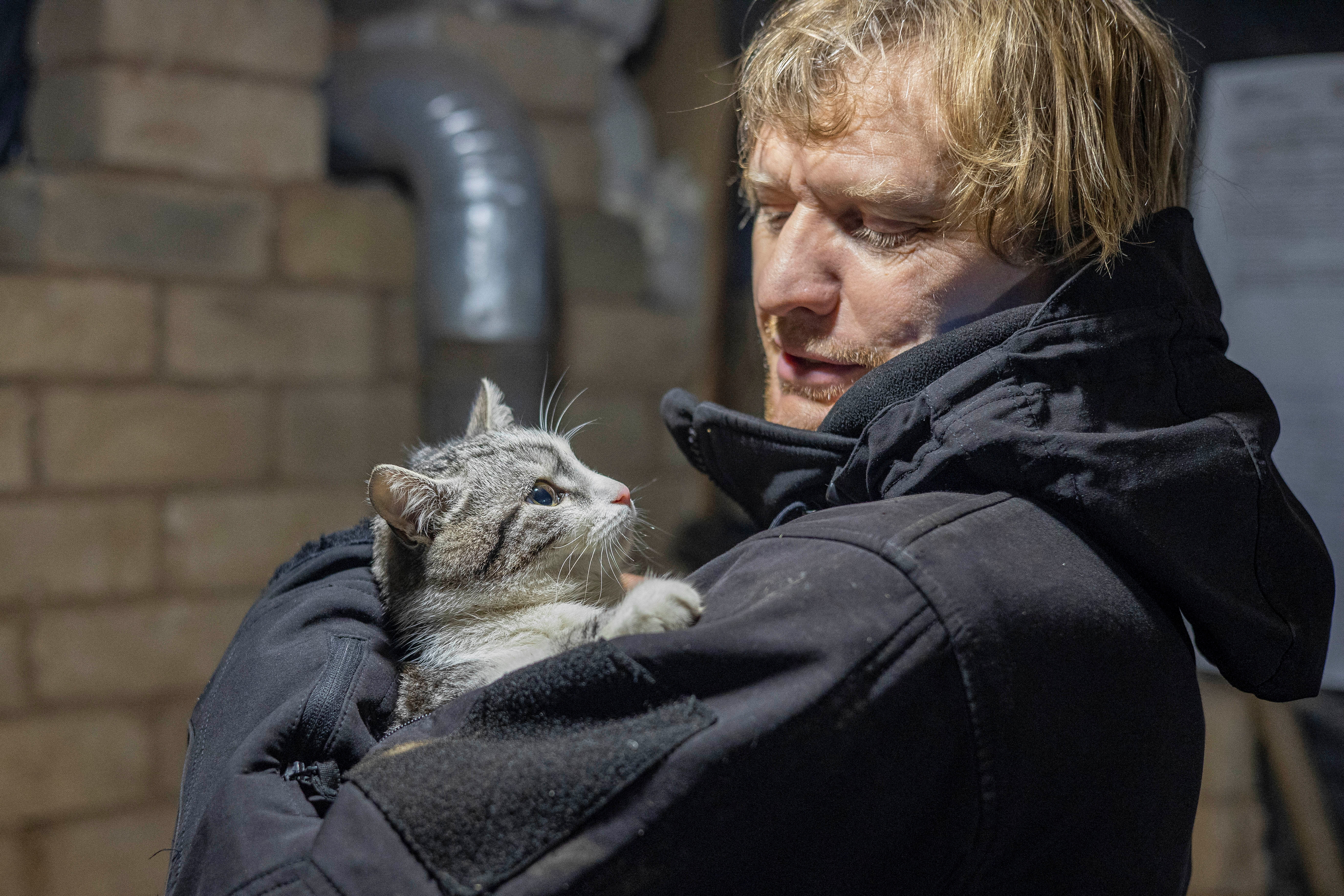 Ukrainian photographer Maksim Levin holds a cat near the line of separation from Russian-backed separatists in Luhansk region, Ukraine January 6, 2022. Picture taken January 6, 2022. REUTERS/Stanislav Kozliuk