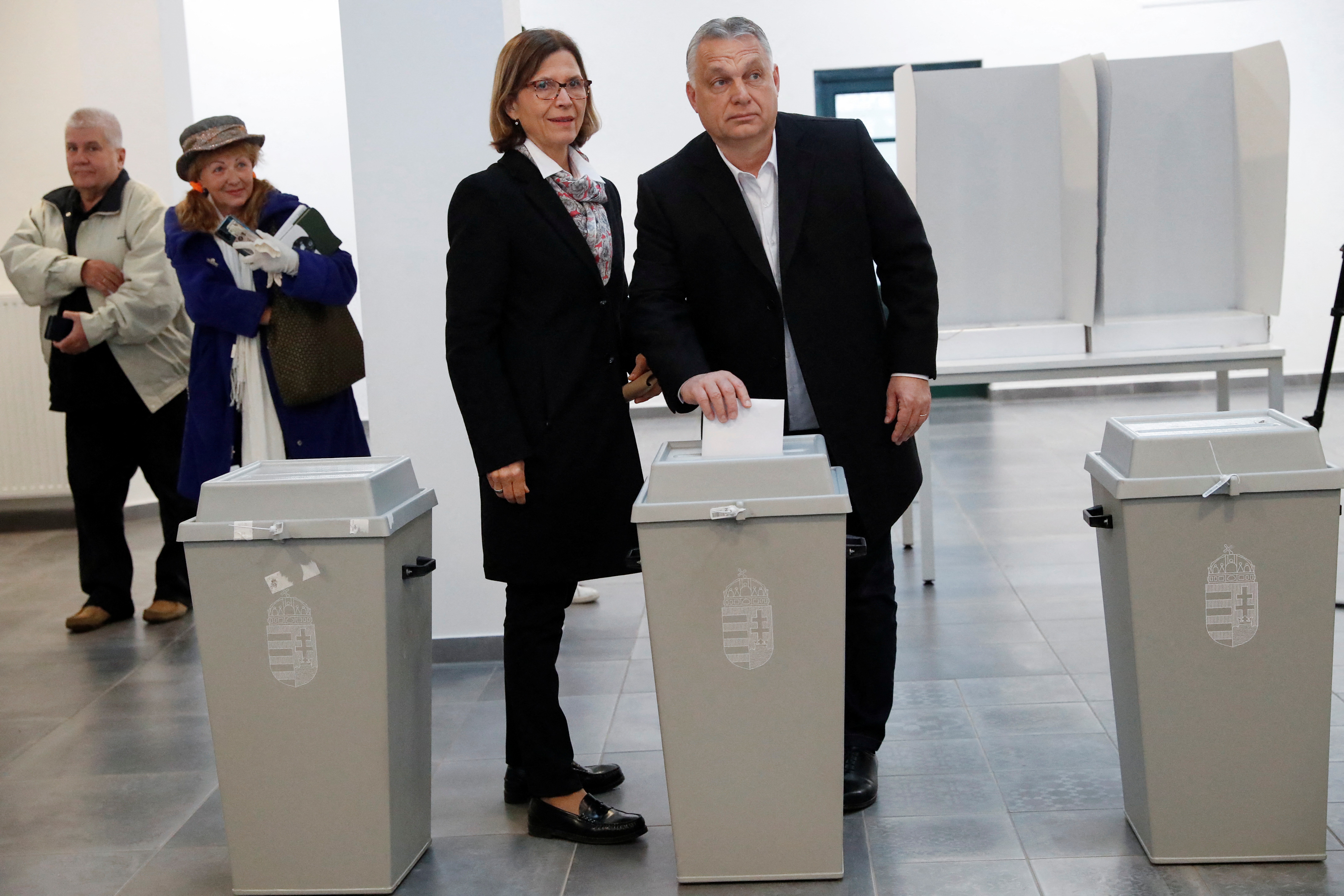 Hungarian Prime Minister Viktor Orban casts his vote while stood next to his wife Aniko Levai, at a polling station during the Hungarian parliamentary election, in Budapest, Hungary, April 3, 2022. REUTERS/Bernadett Szabo