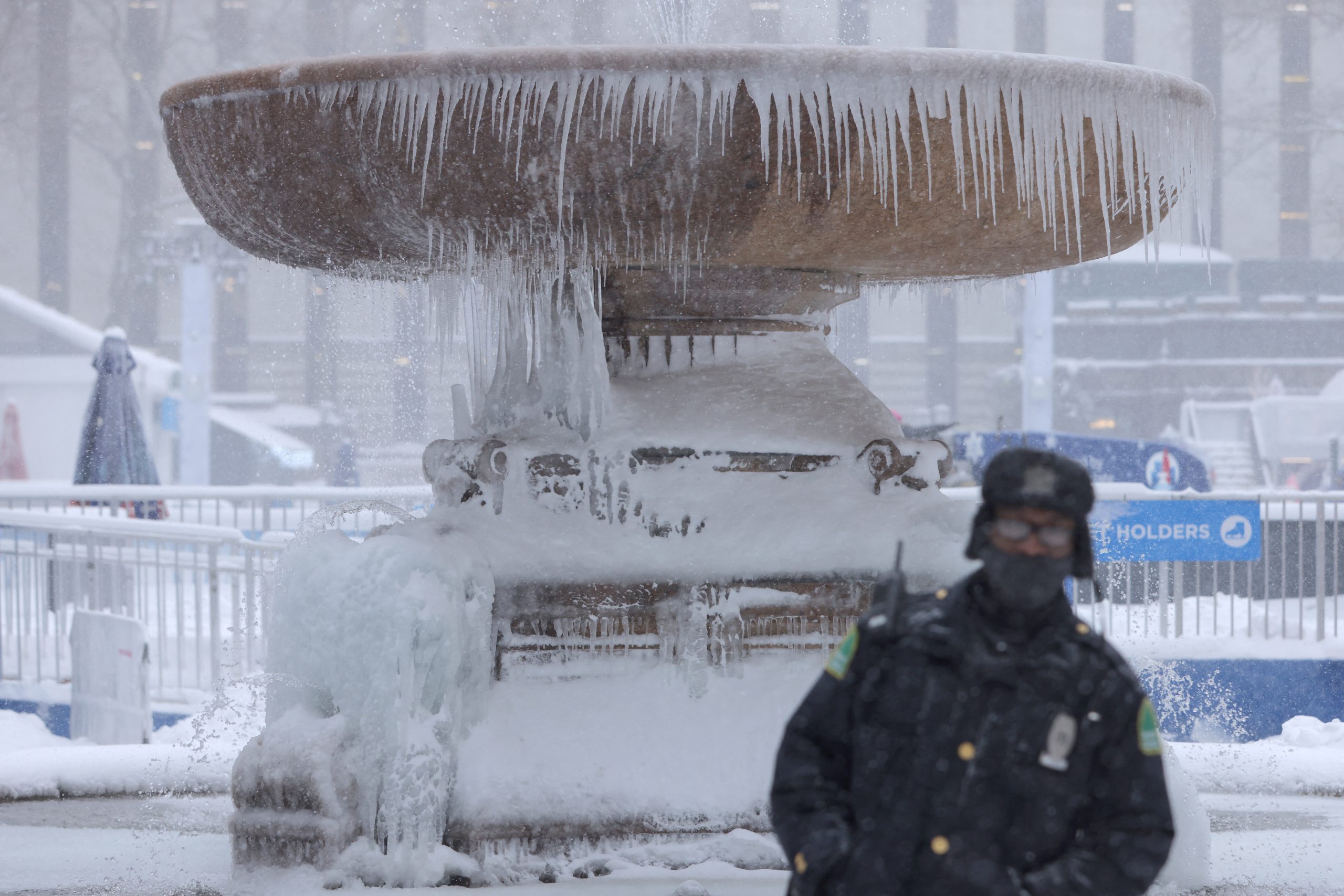 A person stands in front of a frozen fountain in Bryant Park during a Nor'easter storm in Manhattan, New York City, U.S., January 29, 2022. REUTERS/Andrew Kelly