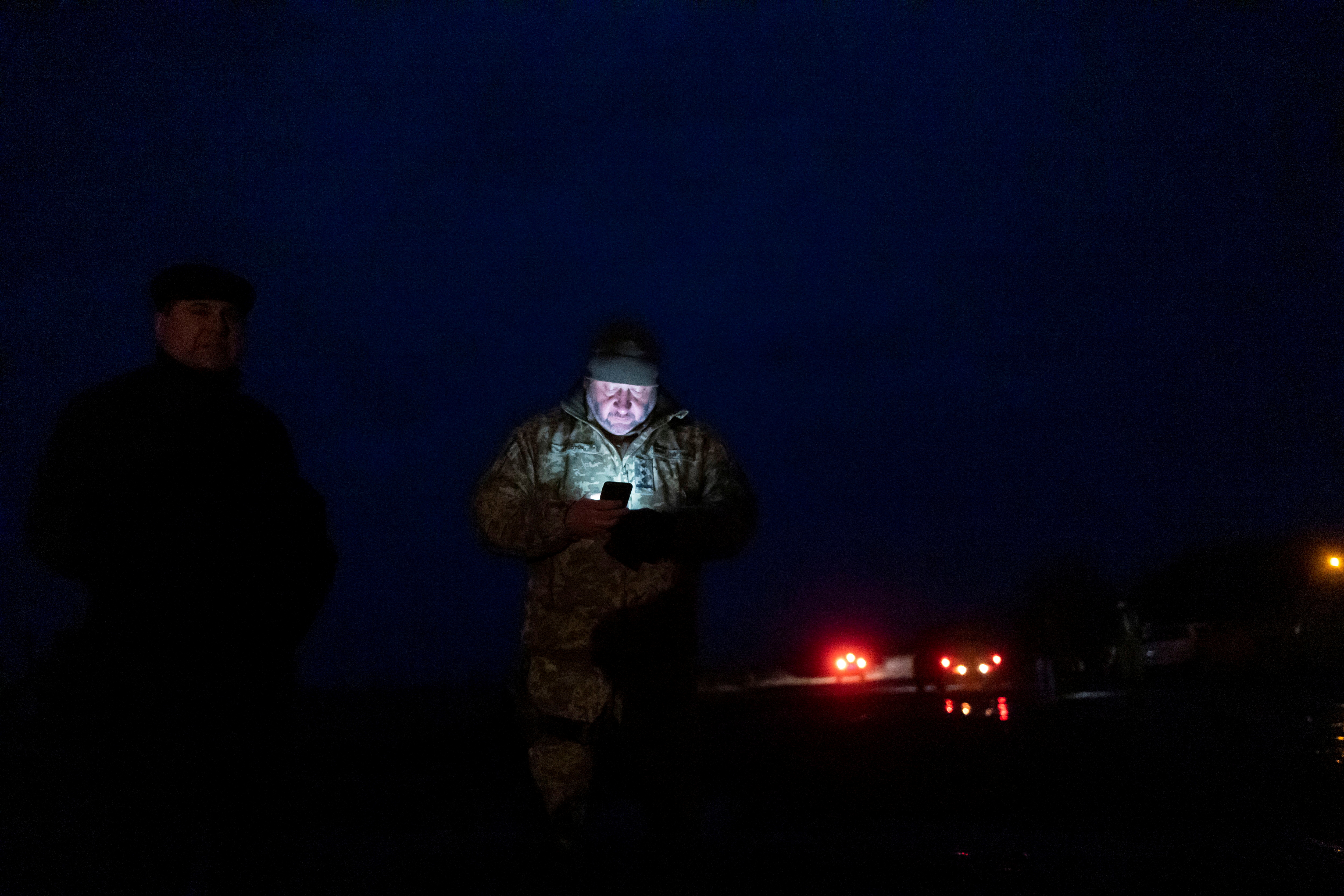 A service member of the Ukrainian armed forces looks at his mobile phone at an airfield near Stanytsia Luhanska, in the Luhansk region, Ukraine