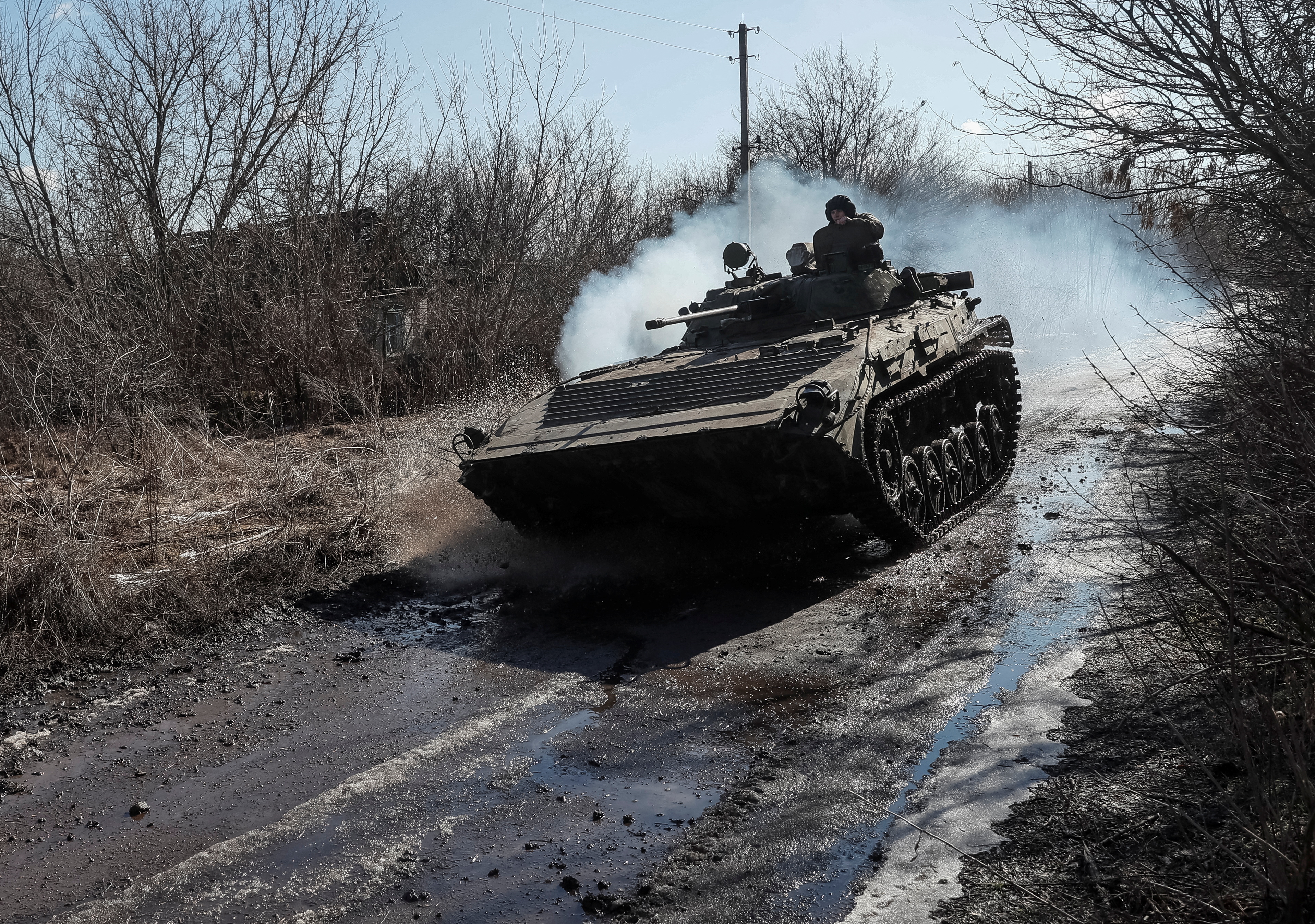 Ukrainian service members ride at a infantry fighting vehicle on the front line near the village of Zaitseve in the Donetsk region, Ukraine February 19, 2022. REUTERS/Gleb Garanich