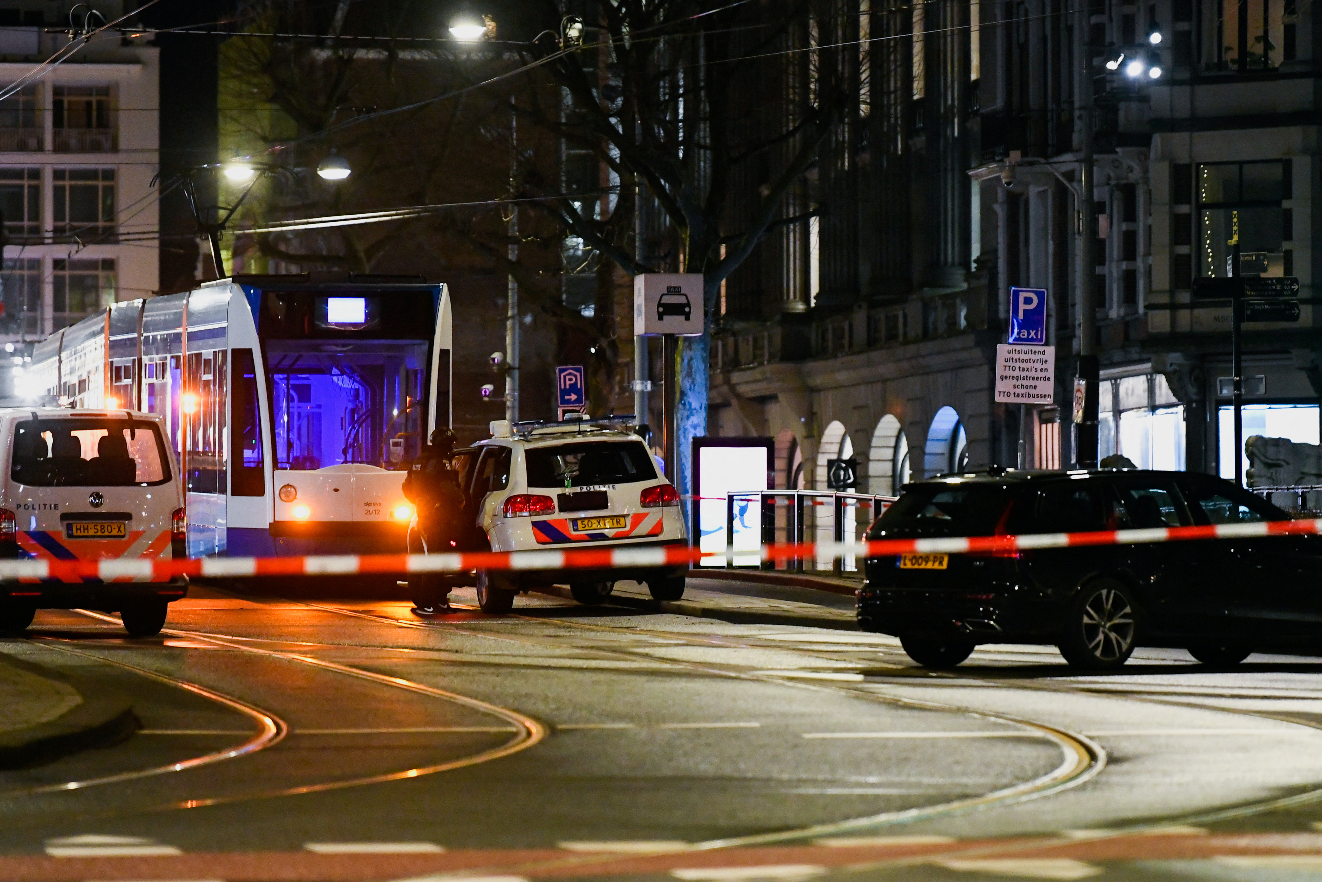 A police officer stands next to a police vehicle near an Apple store in central Amsterdam during a hostage incident in the store, in Amsterdam, Netherlands February 22, 2022. REUTERS/Piroschka van de Wouw