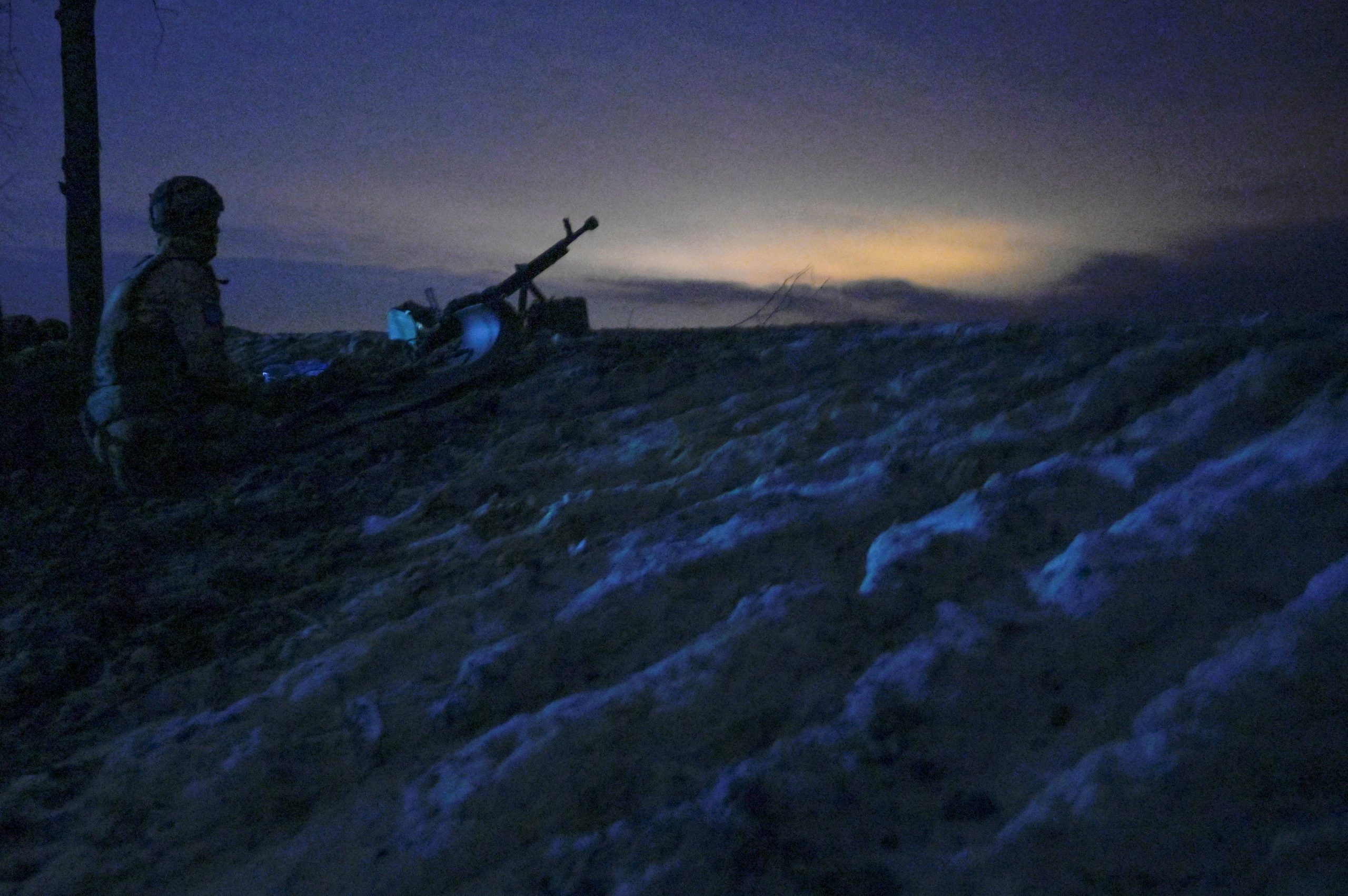 A Ukrainian serviceman sits on the ground at combat positions on the outskirts of Kharkiv, Ukraine February 24, 2022. Picture taken February 24, 2022. REUTERS/Maksim Levin