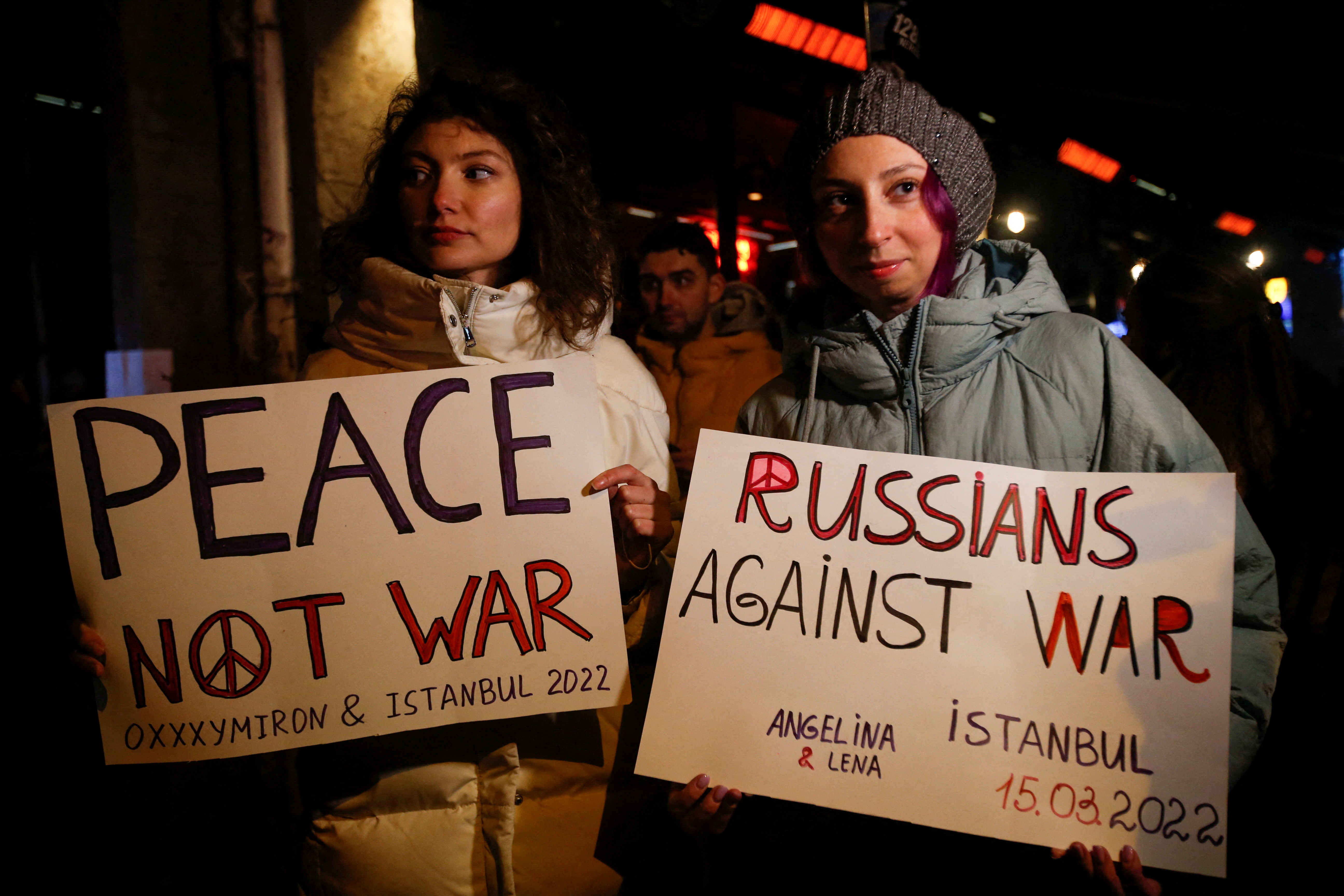 FILE PHOTO: People hold anti-war placards before a rap concert for Ukraine by Russian rapper Oxxxymiron, amid the Russian invasion of Ukraine, in Istanbul, Turkey March 15, 2022. REUTERS/Dilara Senkaya/File Photo