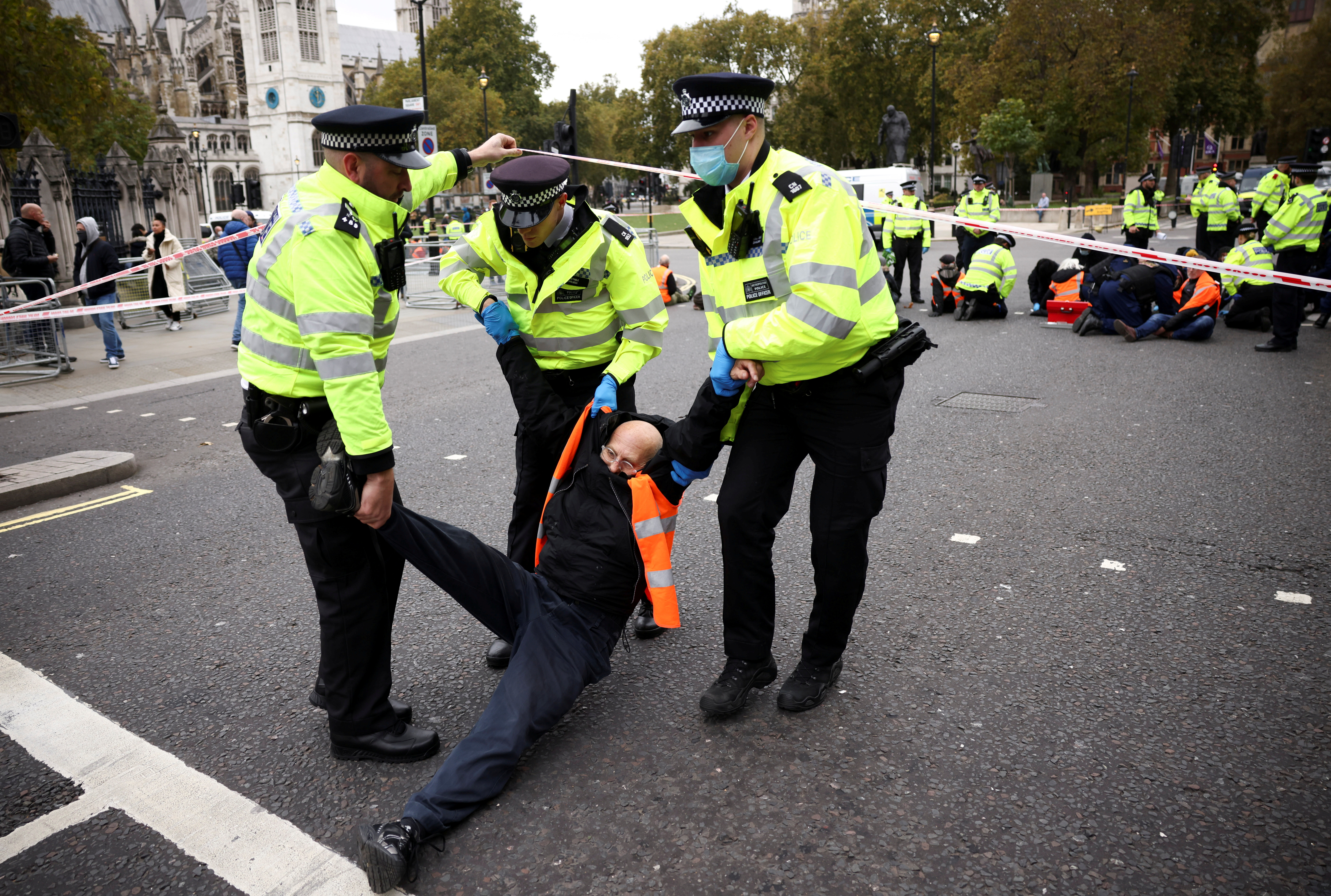 Police officers detain an Insulate Britain activist as they block a road outside the Houses of Parliament during a protest in London, Britain November 4, 2021. REUTERS/Henry Nicholls