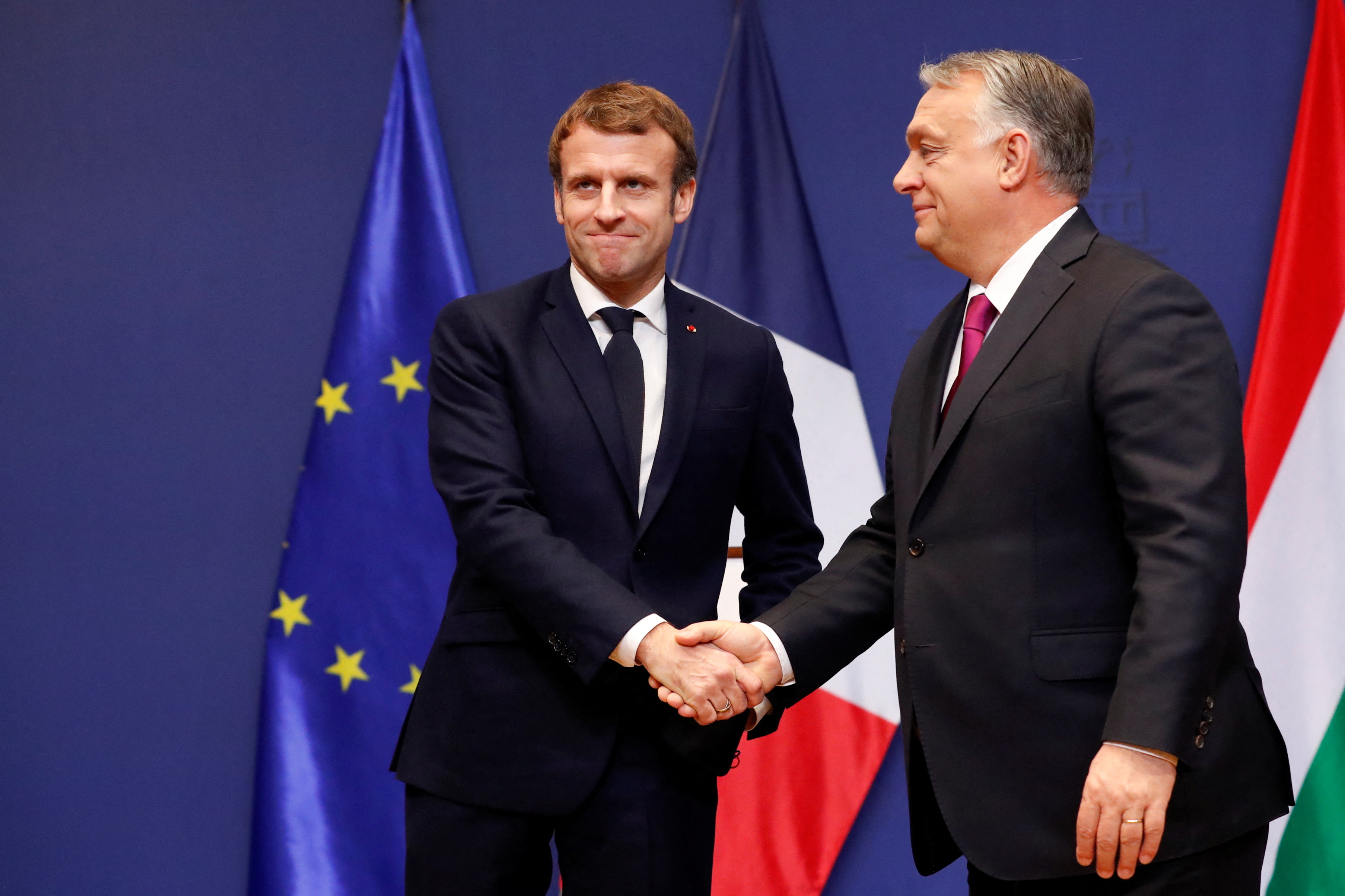 French President Emmanuel Macron and Hungarian Prime Minister Viktor Orban shake hands during a joint statement in Budapest, Hungary, December 13, 2021. REUTERS/Bernadett Szabo