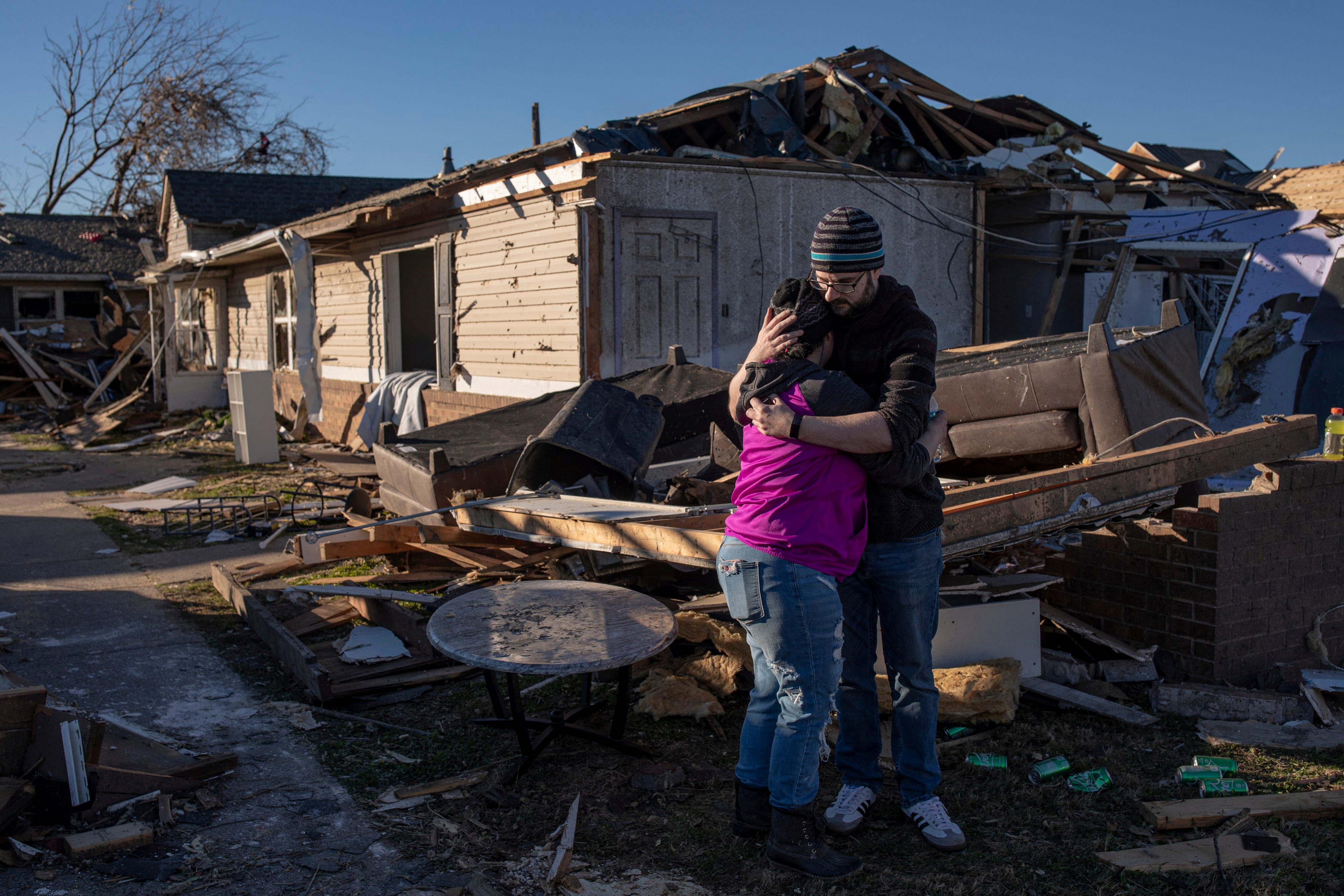 Devin Carlton consoles his fiancee, Asiah Alubahi, outside their former apartment destroyed by a tornado in Maysville