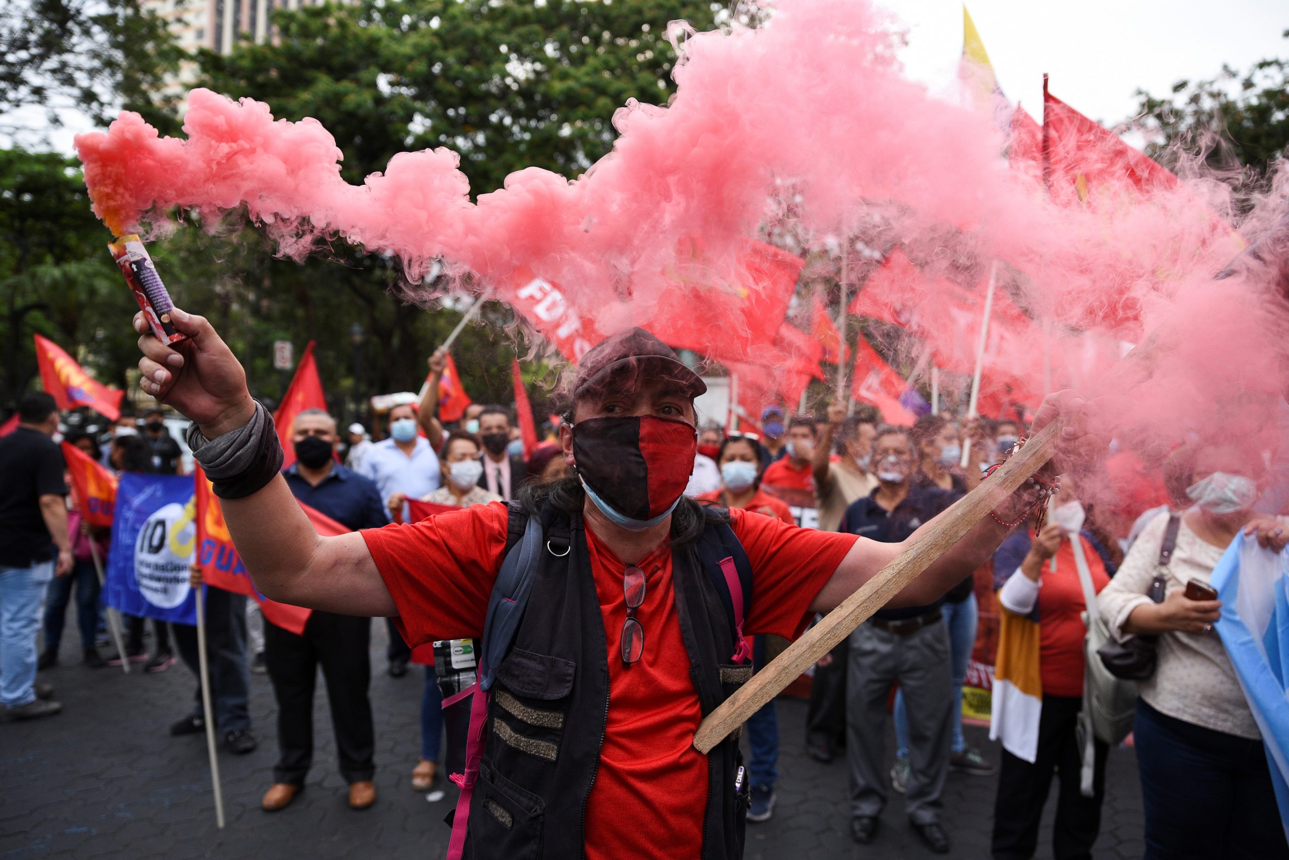 A man holds a smoke bomb during a protest against the economic policies of conservative Ecuadorean President Guillermo Lasso, days after he raised gasoline prices, in Guayaquil, Ecuador October 26, 2021. REUTERS/Vicente Gaibor del Pino