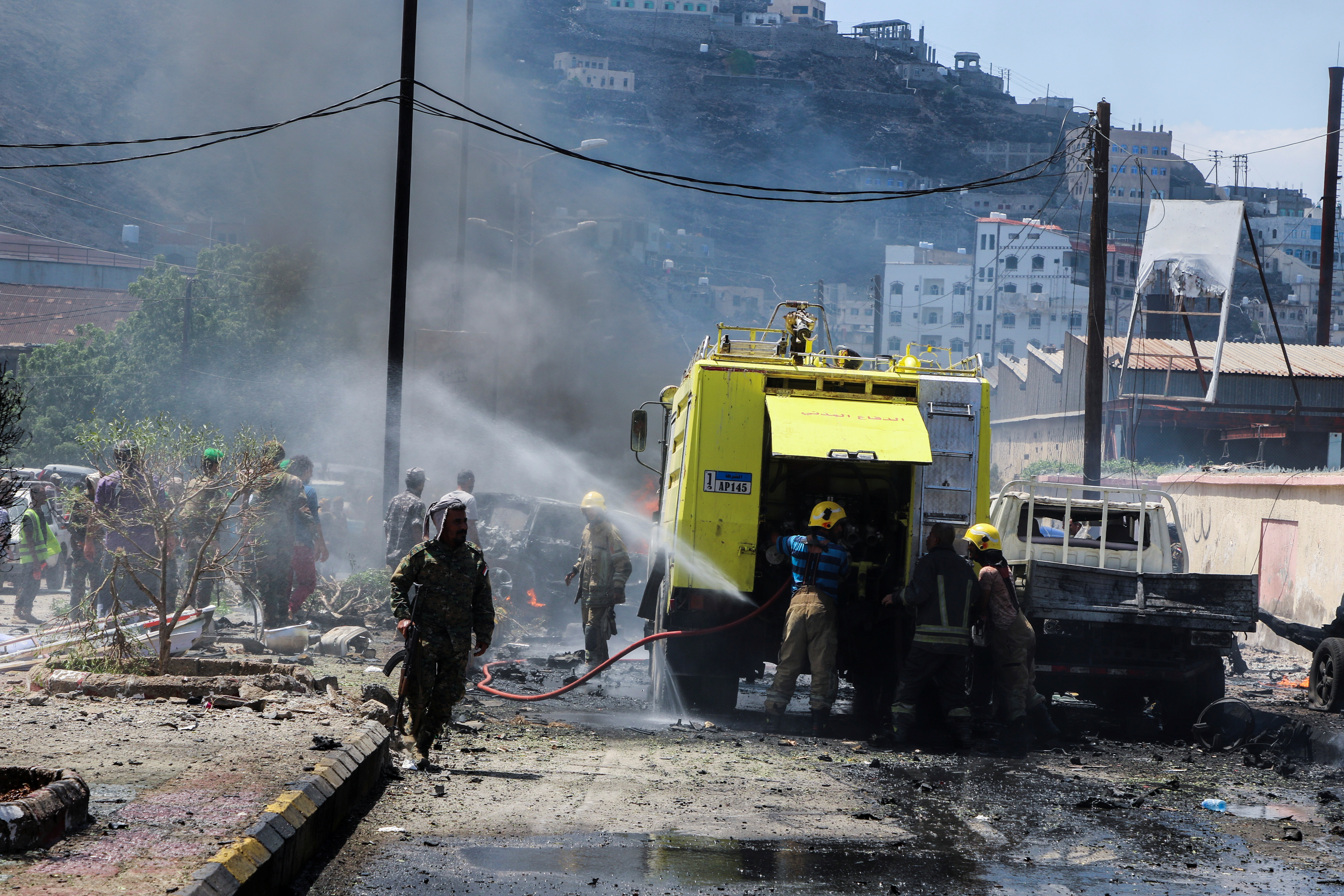 Policemen and firefighters are pictured at the scene of a blast in Aden, Yemen, October 10, 2021. REUTERS/FAWAZ SALMAN