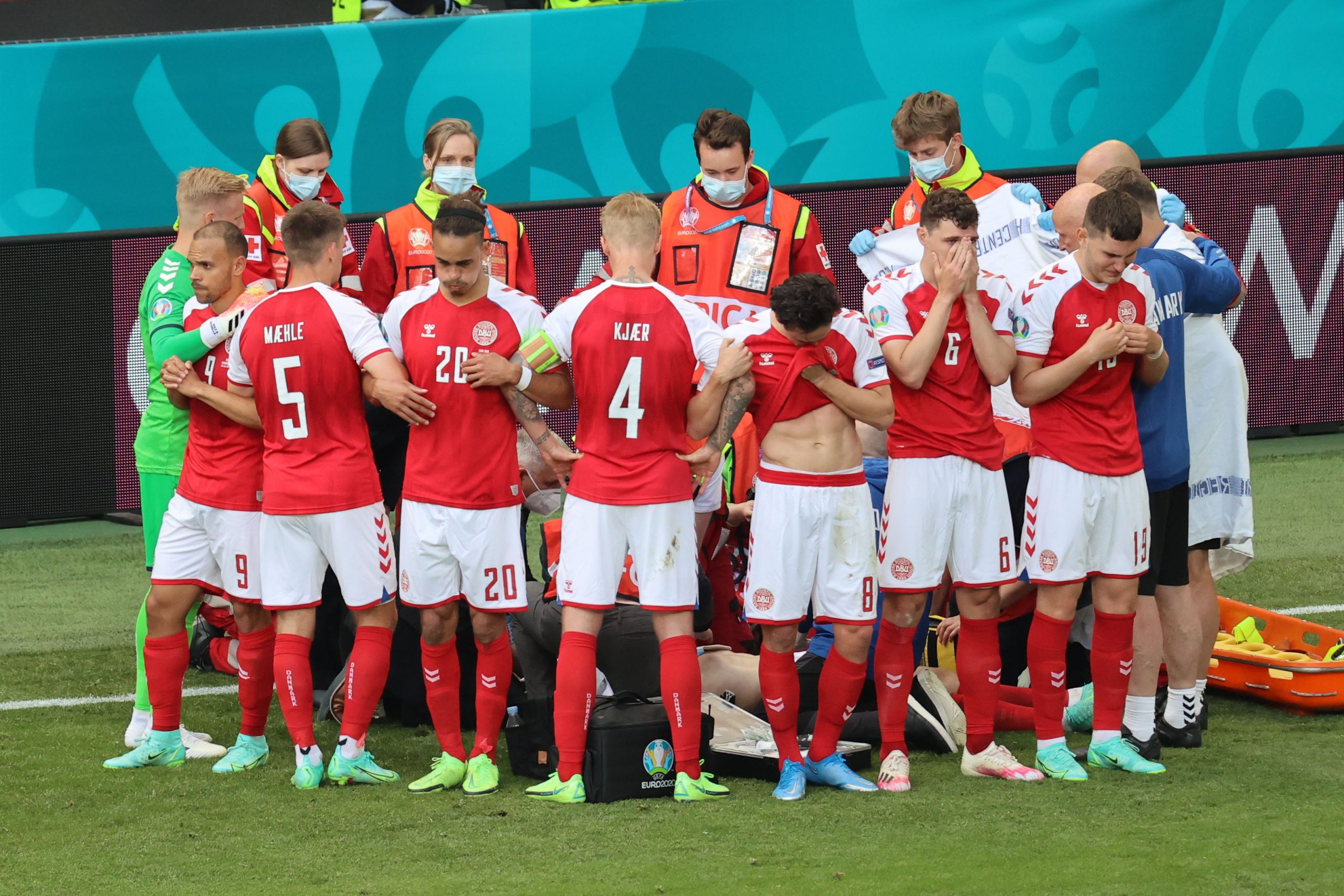 Soccer Football - Euro 2020 - Group B - Denmark v Finland - Parken Stadium, Copenhagen, Denmark - June 12, 2021 Denmark players react as Christian Eriksen receives medical attention after collapsing during the match Pool via REUTERS/Wolfgang Rattay
