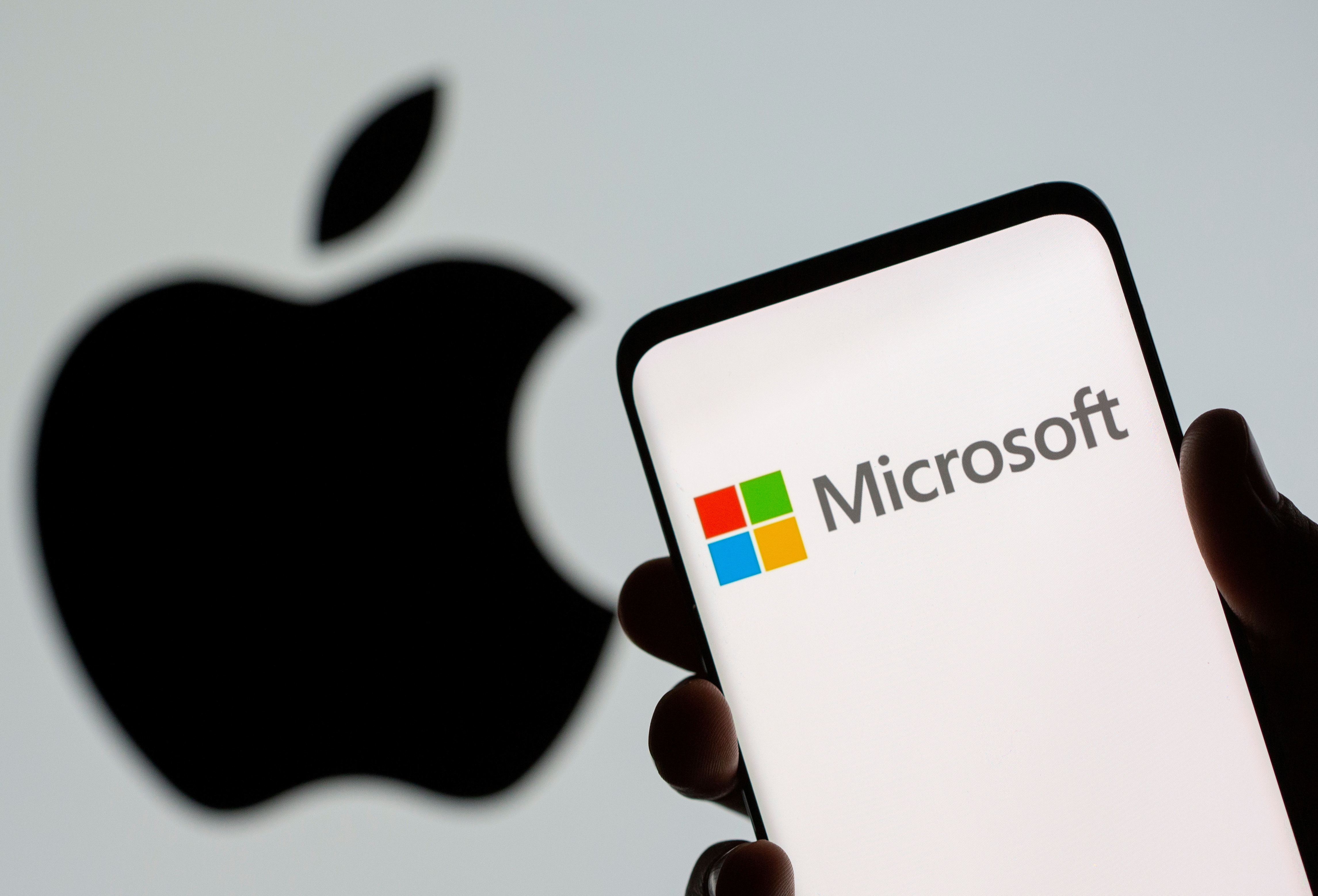 FILE PHOTO: Microsoft logo is seen on the smartphone in front of displayed Apple logo in this illustration taken