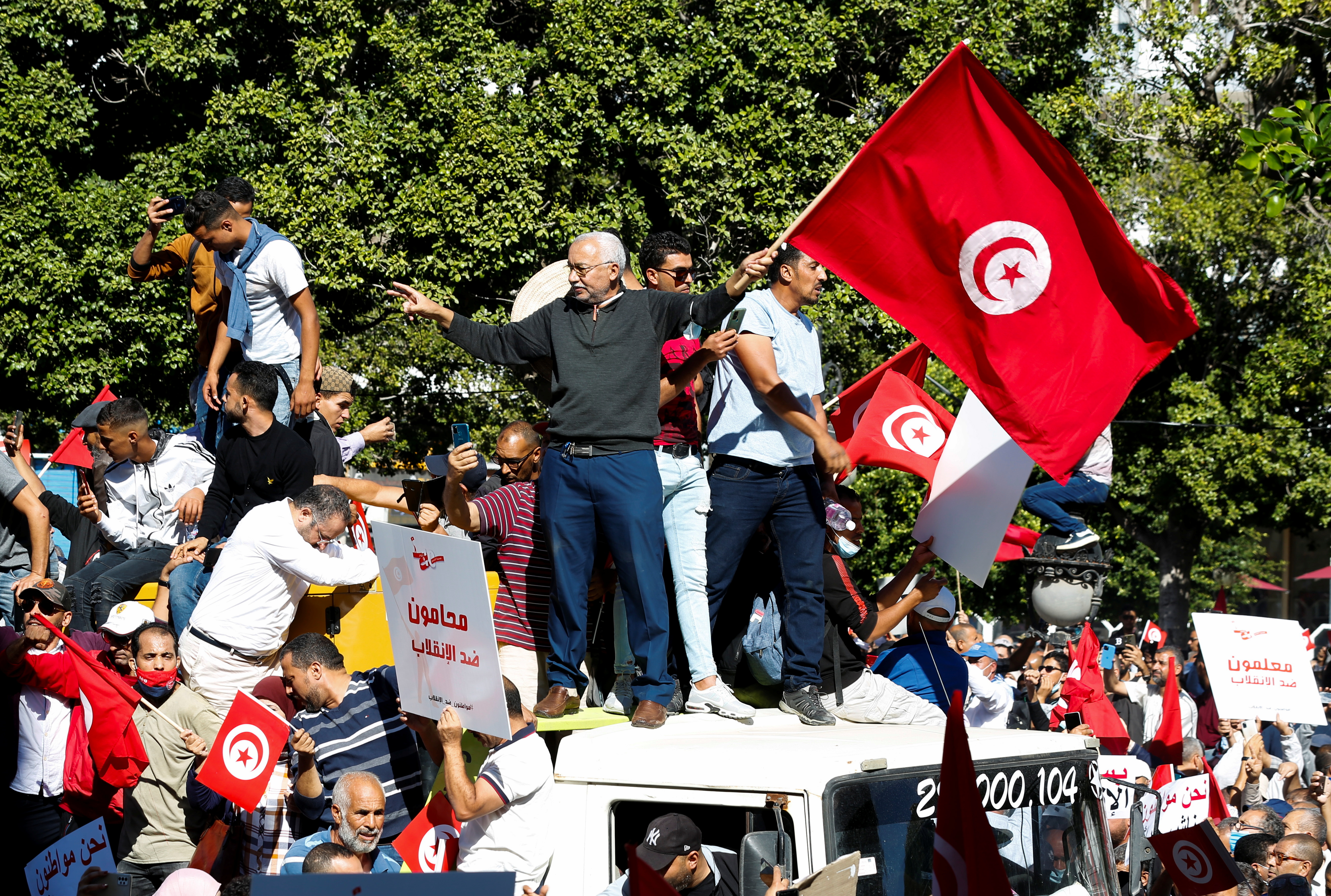 Demonstrators carry flags and banners during a protest against Tunisian President Kais Saied's seizure of governing powers, in Tunis, Tunisia, October 10, 2021. REUTERS/Zoubeir Souissi