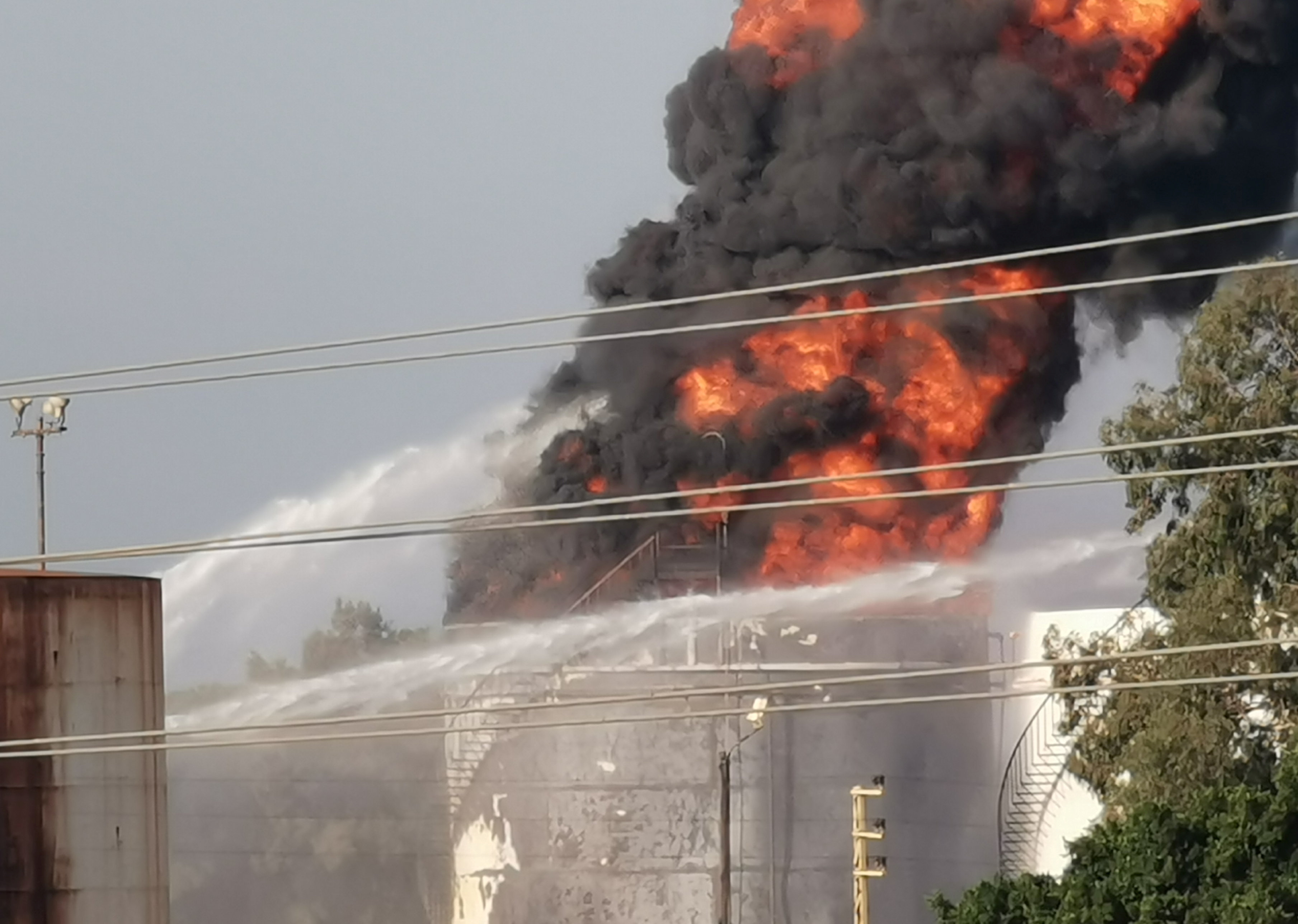 Water is sprayed at a fire in the Zahrani oil facility in southern Lebanon