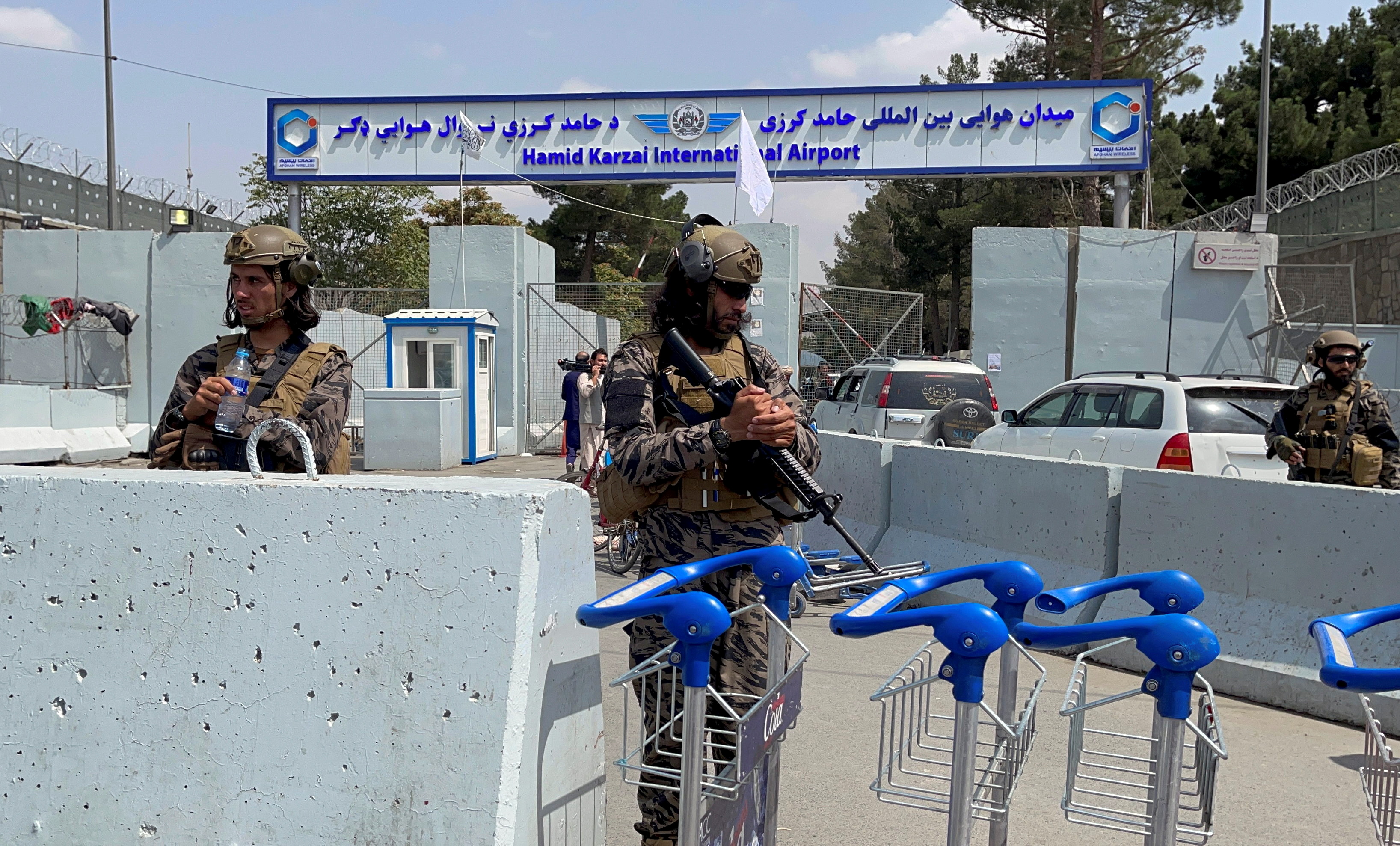FILE PHOTO: Taliban forces stand guard at the  entrance gate of Hamid Karzai International Airport a day after U.S troops withdrawal in Kabul