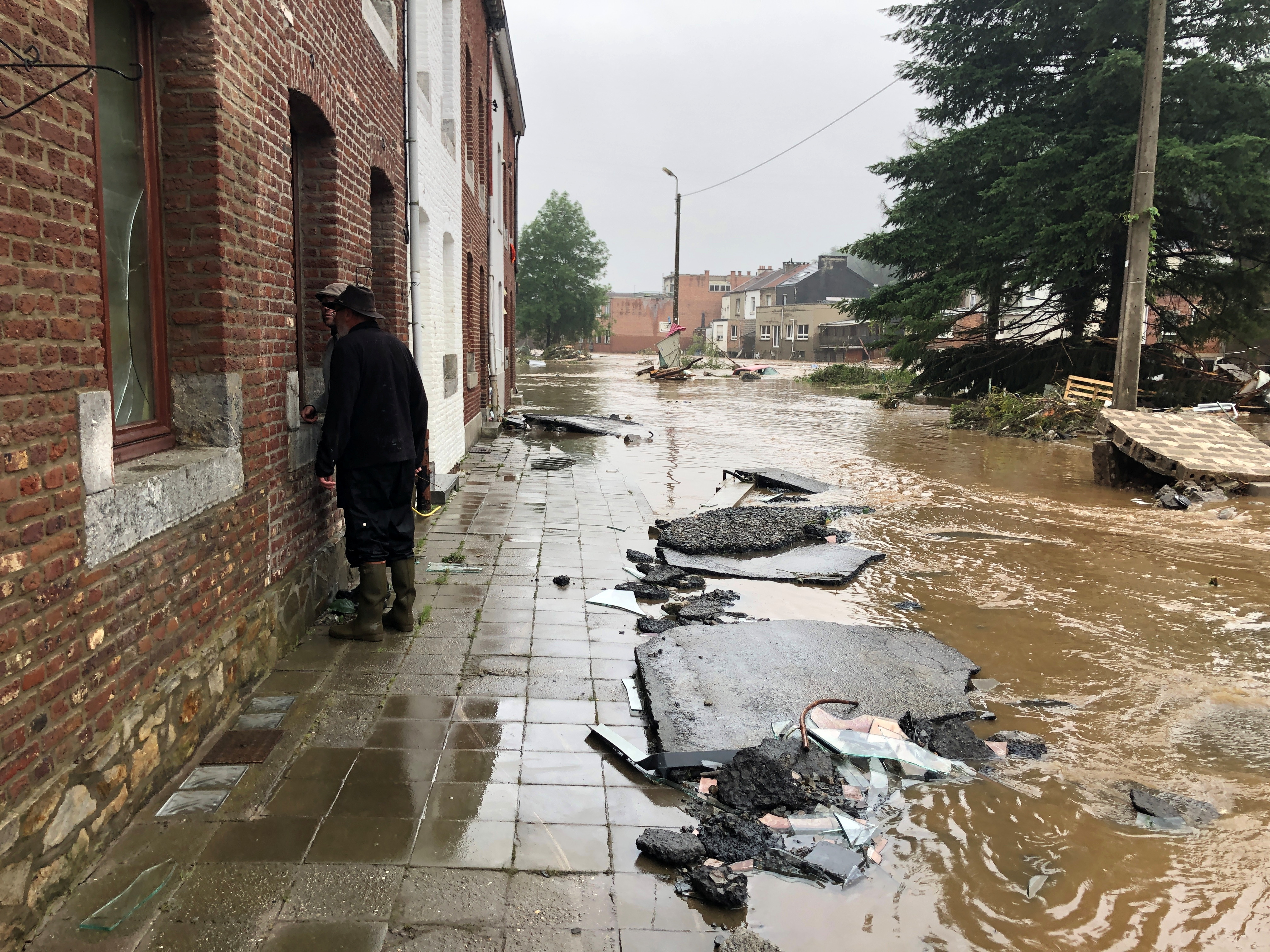 Belgija, poplava, poplave, nevreme
People stand on a sidewalk of a flooded street in Pepinster, Belgium July 15, 2021. REUTERS/Bart Biesemans
