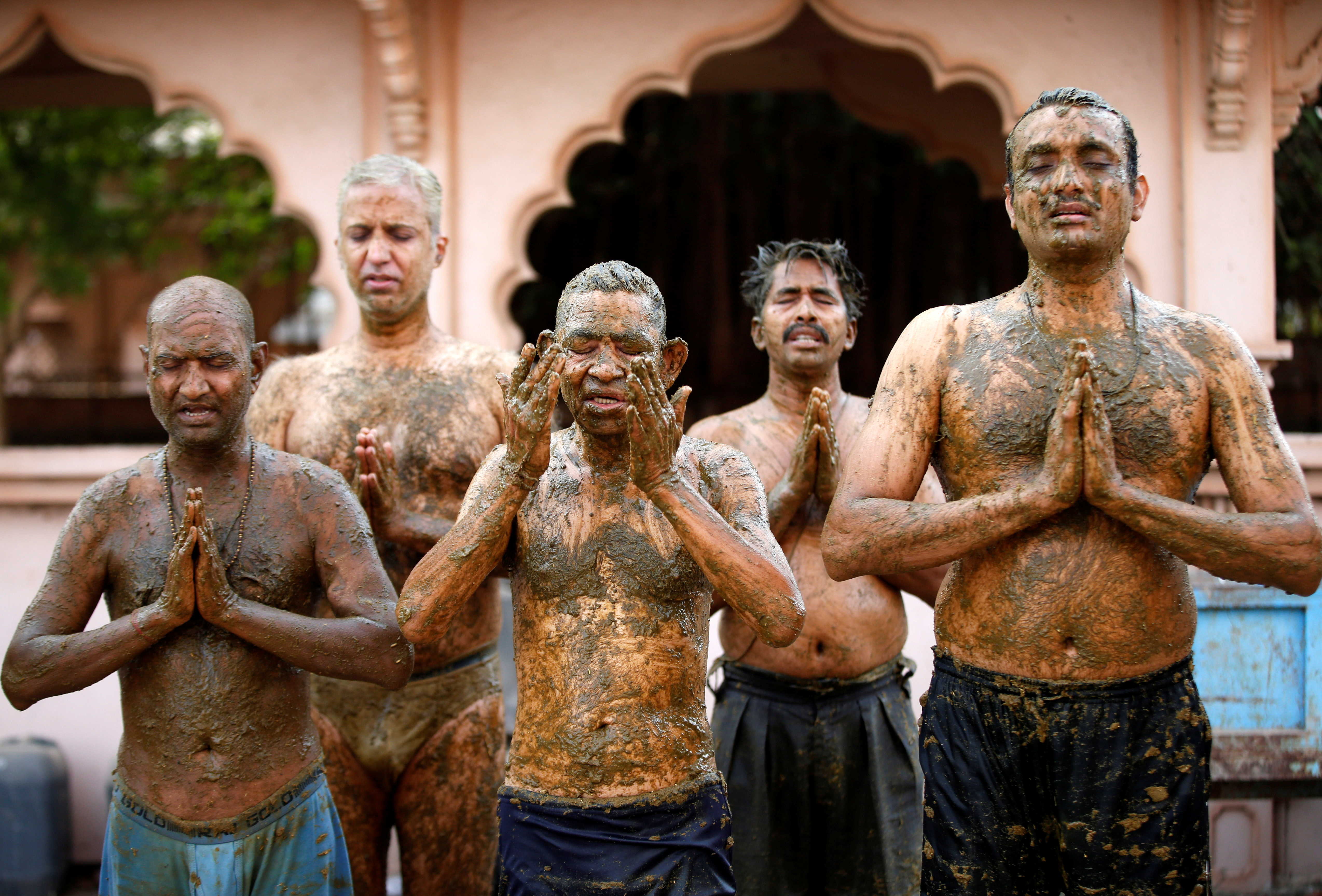 foto dana People pray after applying cow dung on their bodies during "cow dung therapy" on outskirts of Ahmedabad