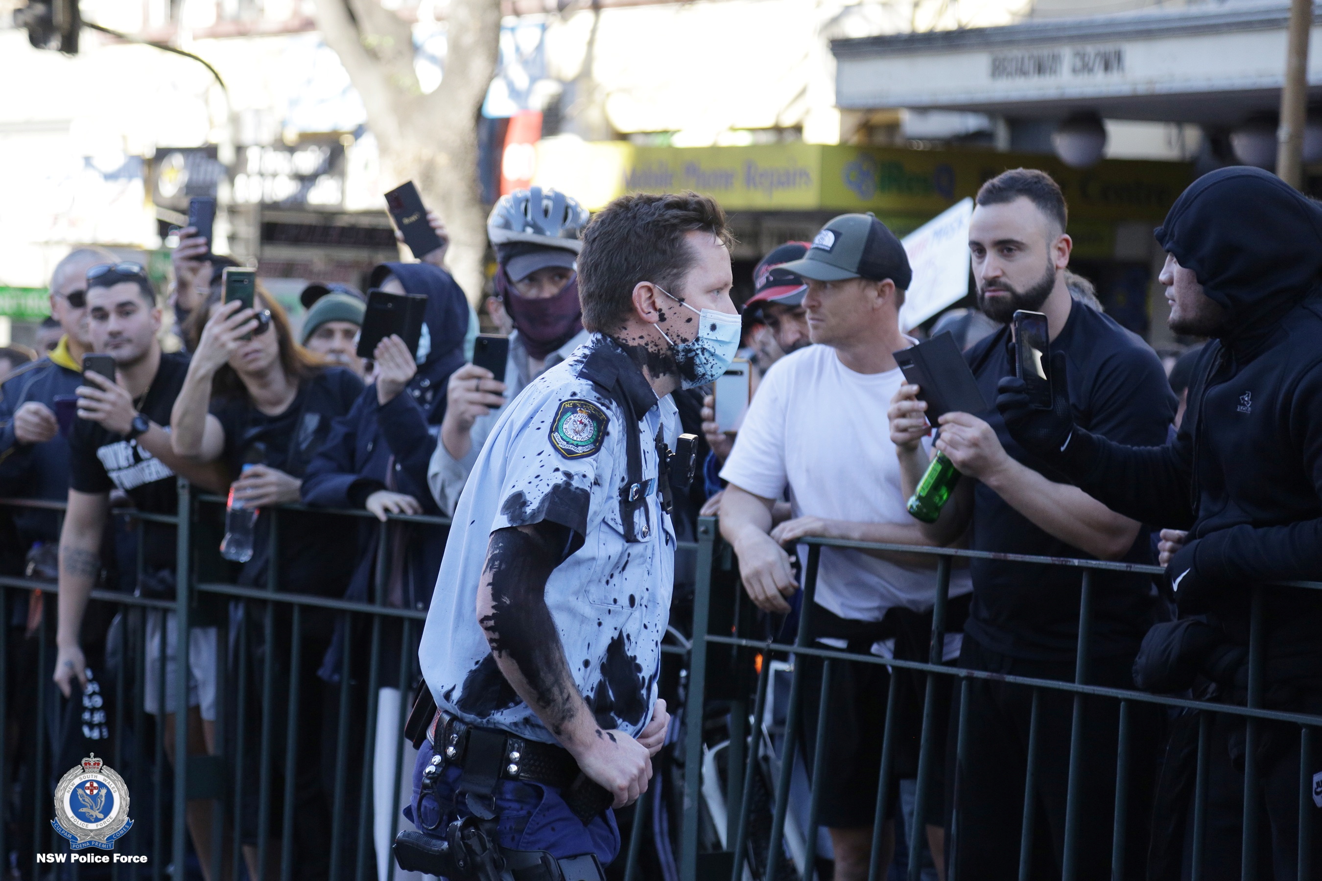 A police officer is covered in black ink after clashes at an anti-lockdown demonstration in Sydney