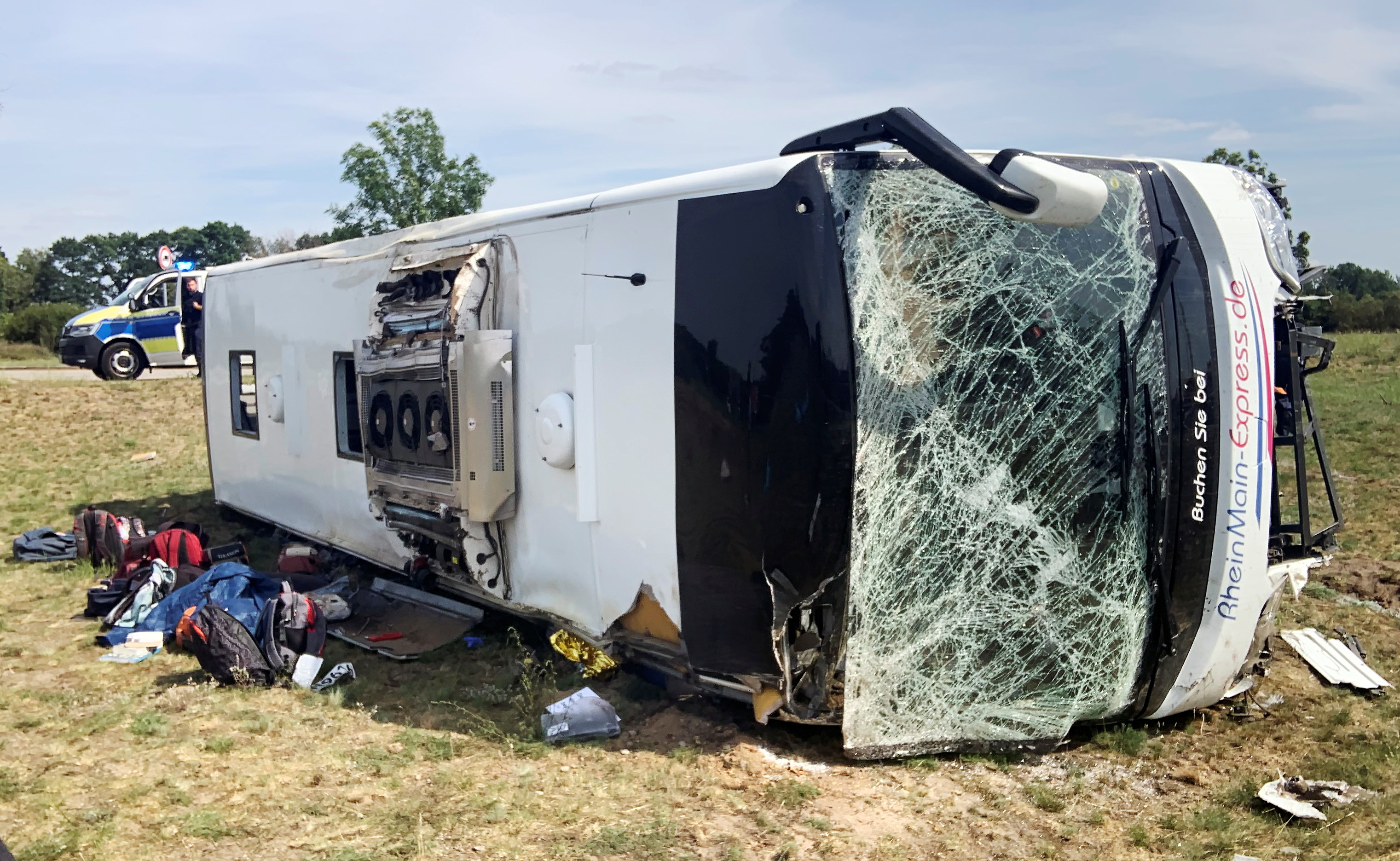 Police officers stand close to a crashed bus at a highway near Schoenwald, southeast of Berlin, Germany, July 30, 2021. REUTERS/Oliver Barth