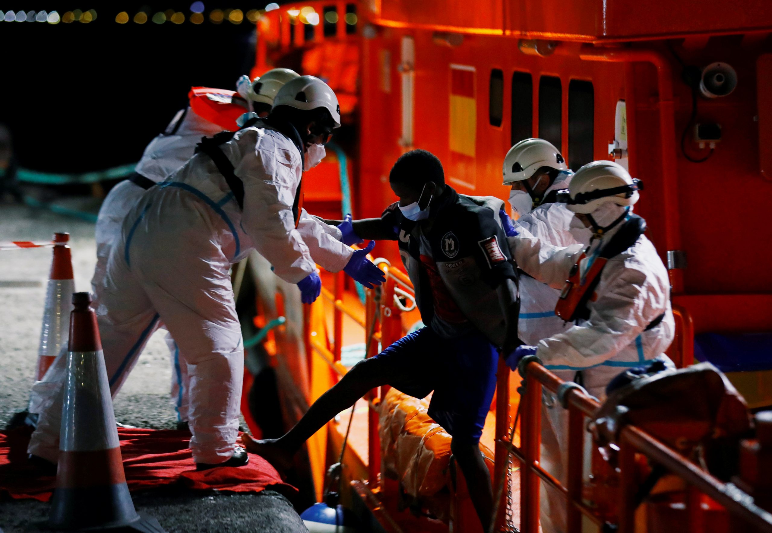 A migrant is disembarked from a Spanish coast guard vessel, in the port of Arguineguin, to the island of Gran Canaria, Spain March 9, 2021. REUTERS/Borja Suarez