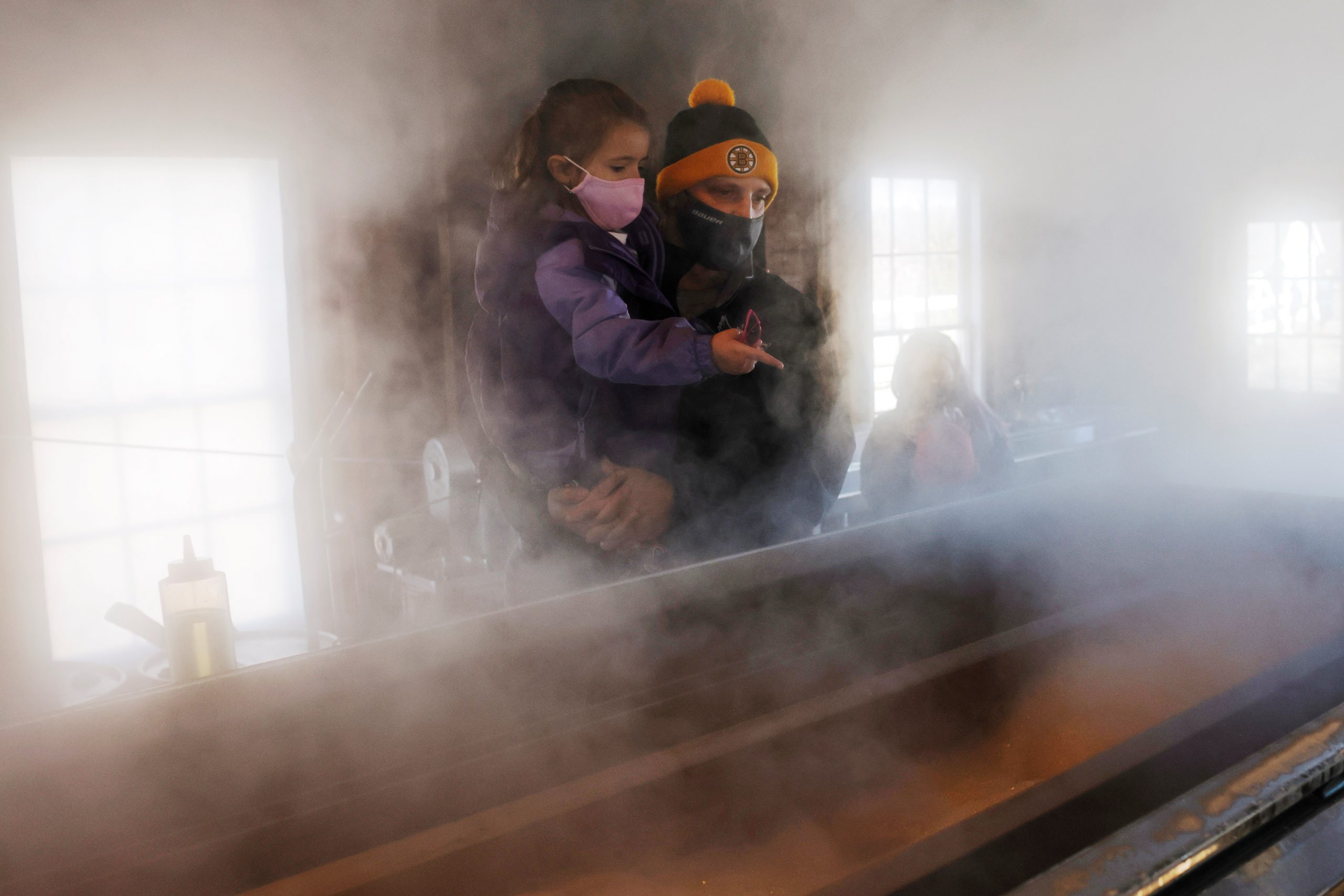 Visitors watch as sap from maple trees is boiled down into maple syrup in the evaporator in the sugar house at Hollis Hills Farm in Fitchburg, Massachusetts, U.S., March 13, 2021. REUTERS/Brian Snyder