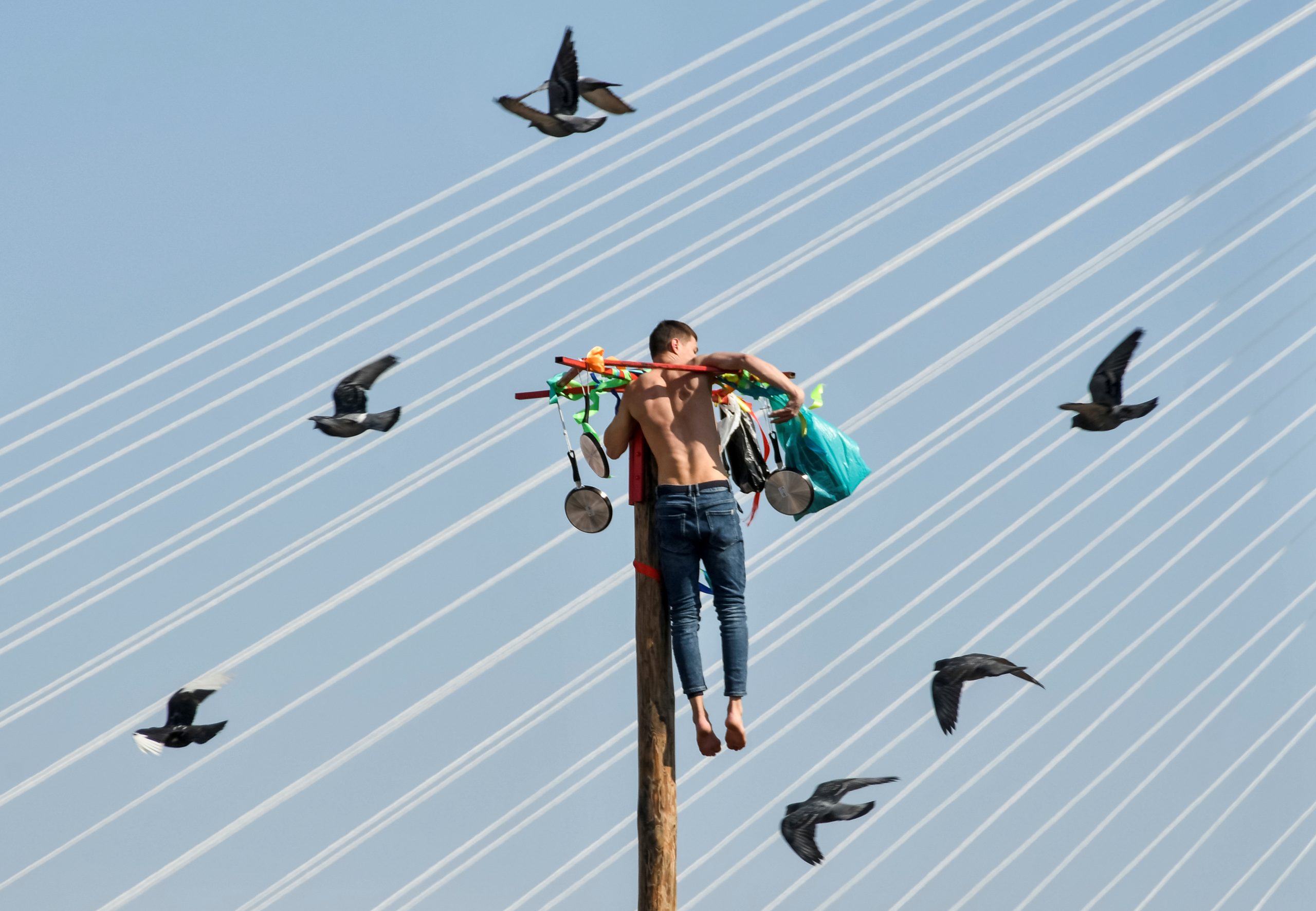 A man climbs up a wooden pole to get a prize during celebrations of Maslenitsa, also known as Pancake Week, which is a pagan holiday marking the end of winter, in Russia's far eastern city of Vladivostok, Russia March 14, 2021. REUTERS/Yuri Maltsev