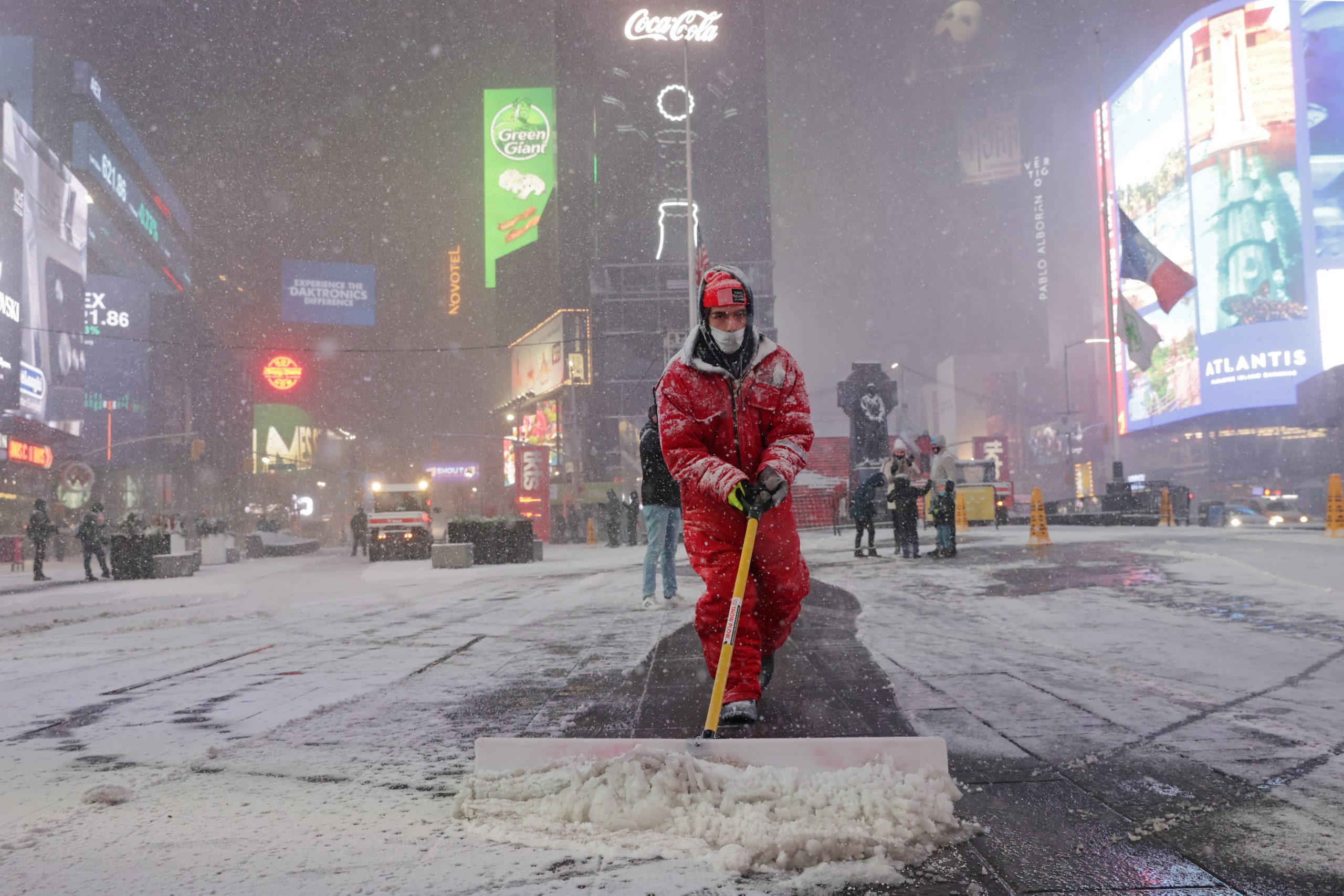 A worker clears snow as snow begins to fall in Times Square during a Nor'easter, during the coronavirus disease (COVID-19) pandemic in the Manhattan borough of New York City, New York, U.S., December 16, 2020. REUTERS/Jeenah Moon